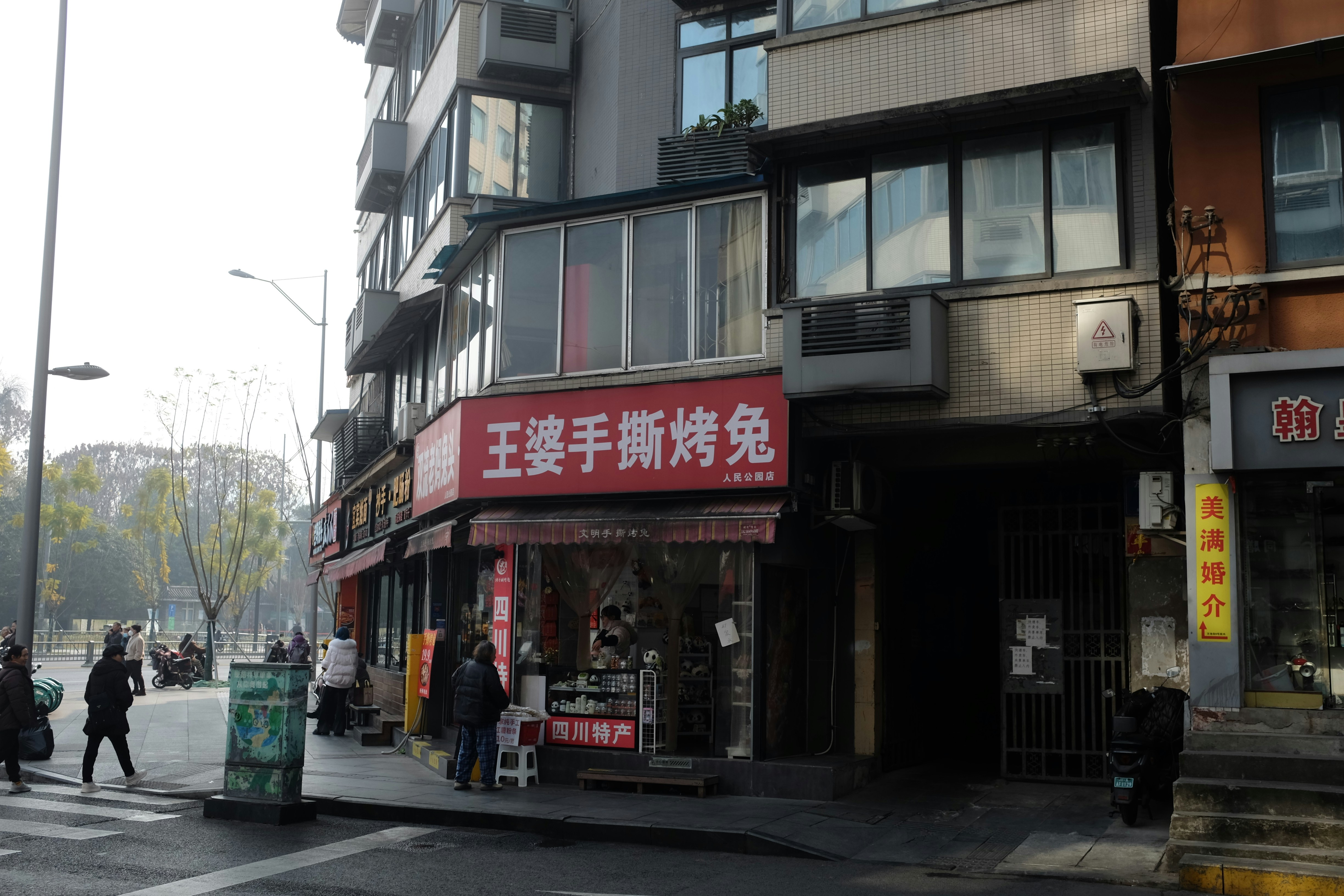 Street scene with shops and pedestrians on a sunny day.