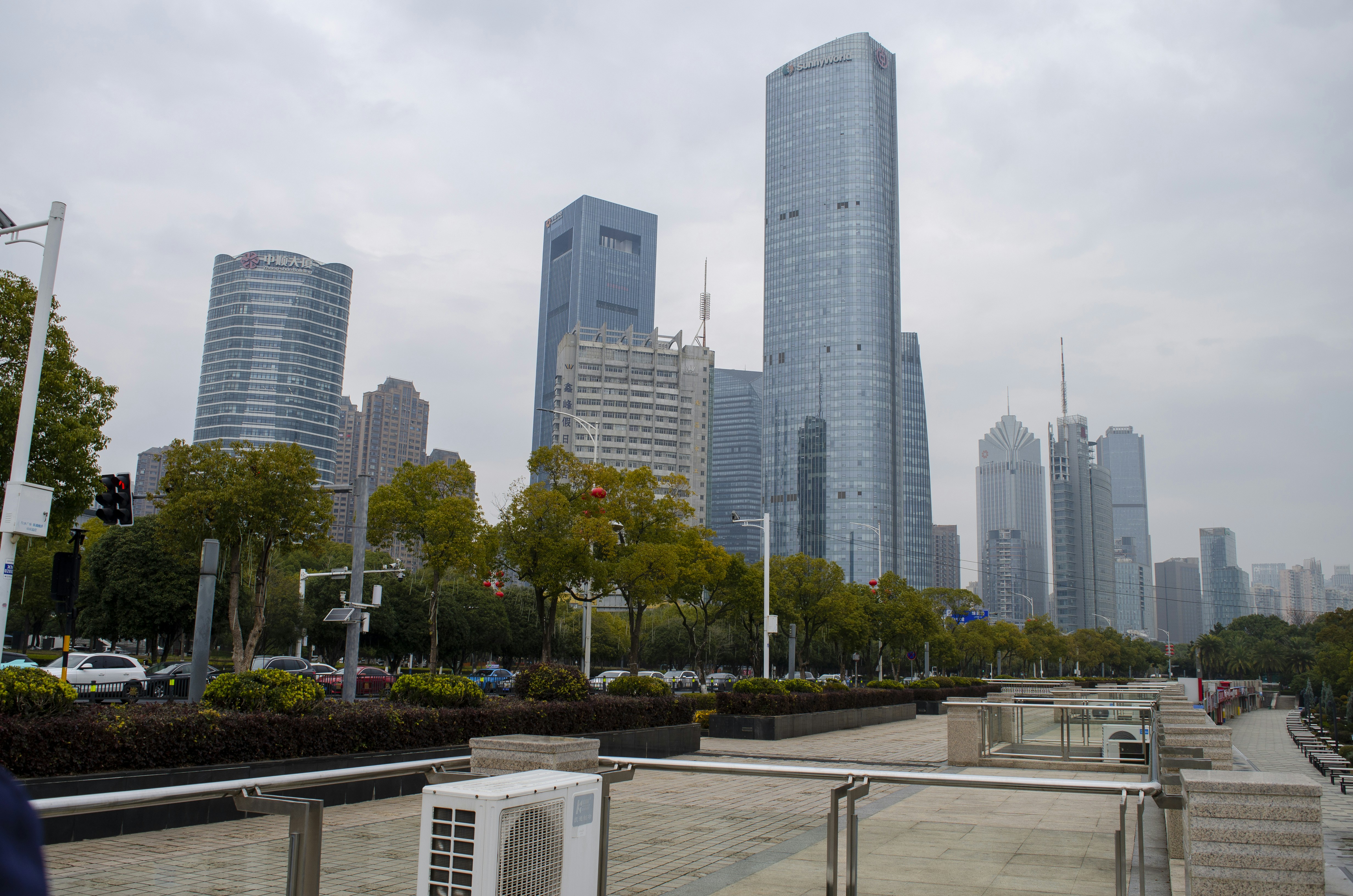 Les gratte-ciel modernes dominent la silhouette d’une ville sous un ciel nuageux.
