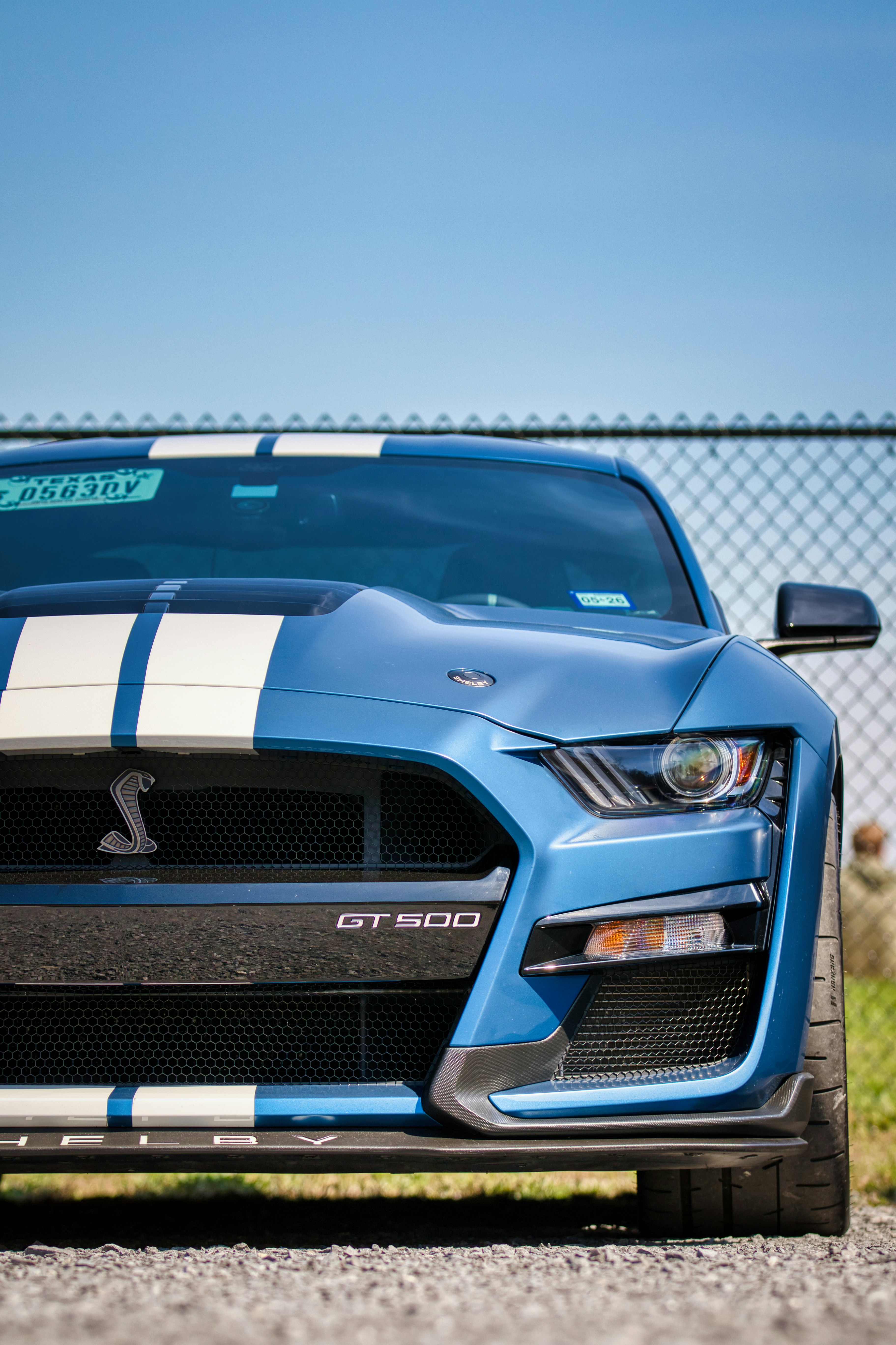 Un Ford Mustang GT500 azul con rayas blancas.