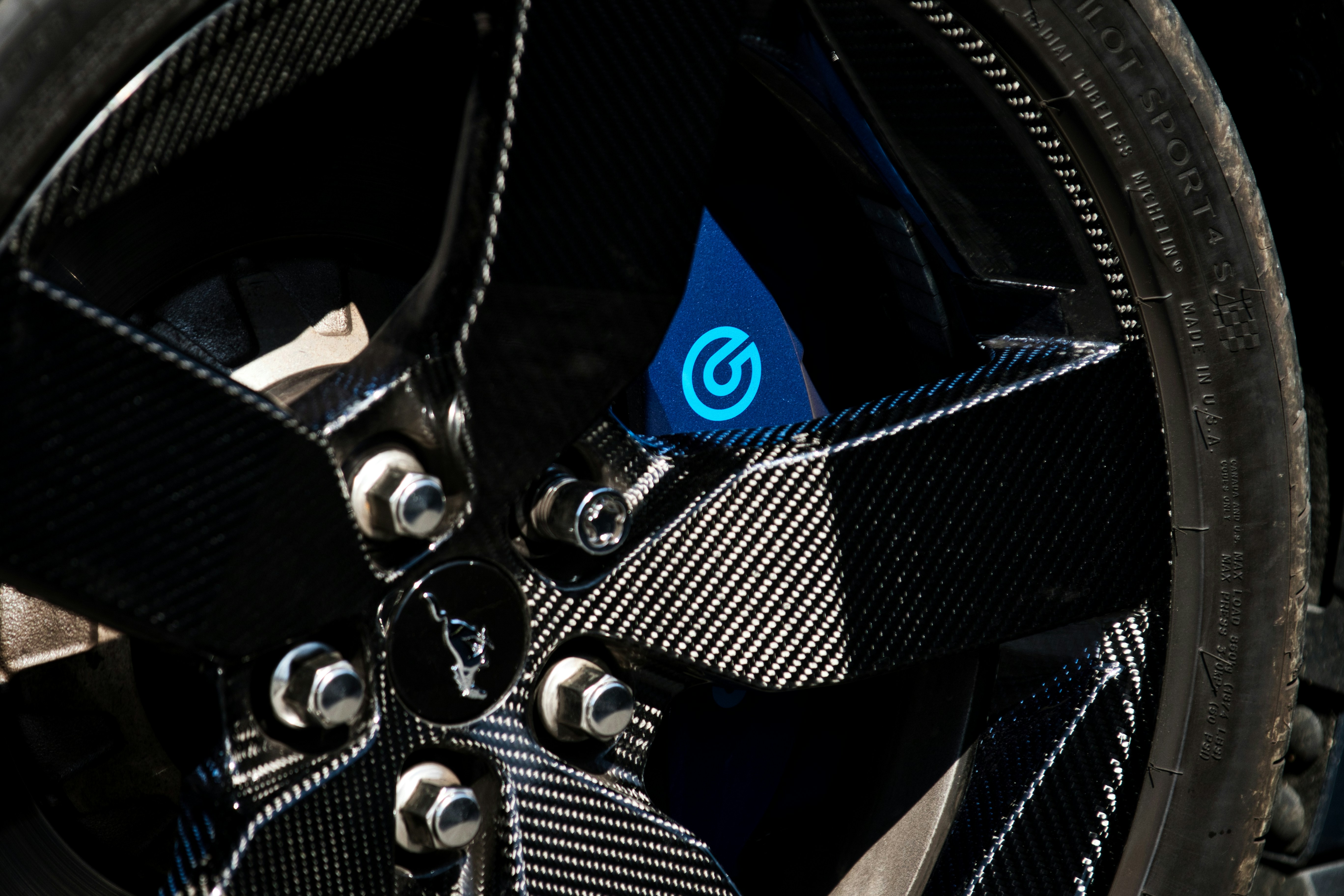 Close-up of a car wheel with a blue brake caliper. (Photo by Chandler Cruttenden on Unsplash)