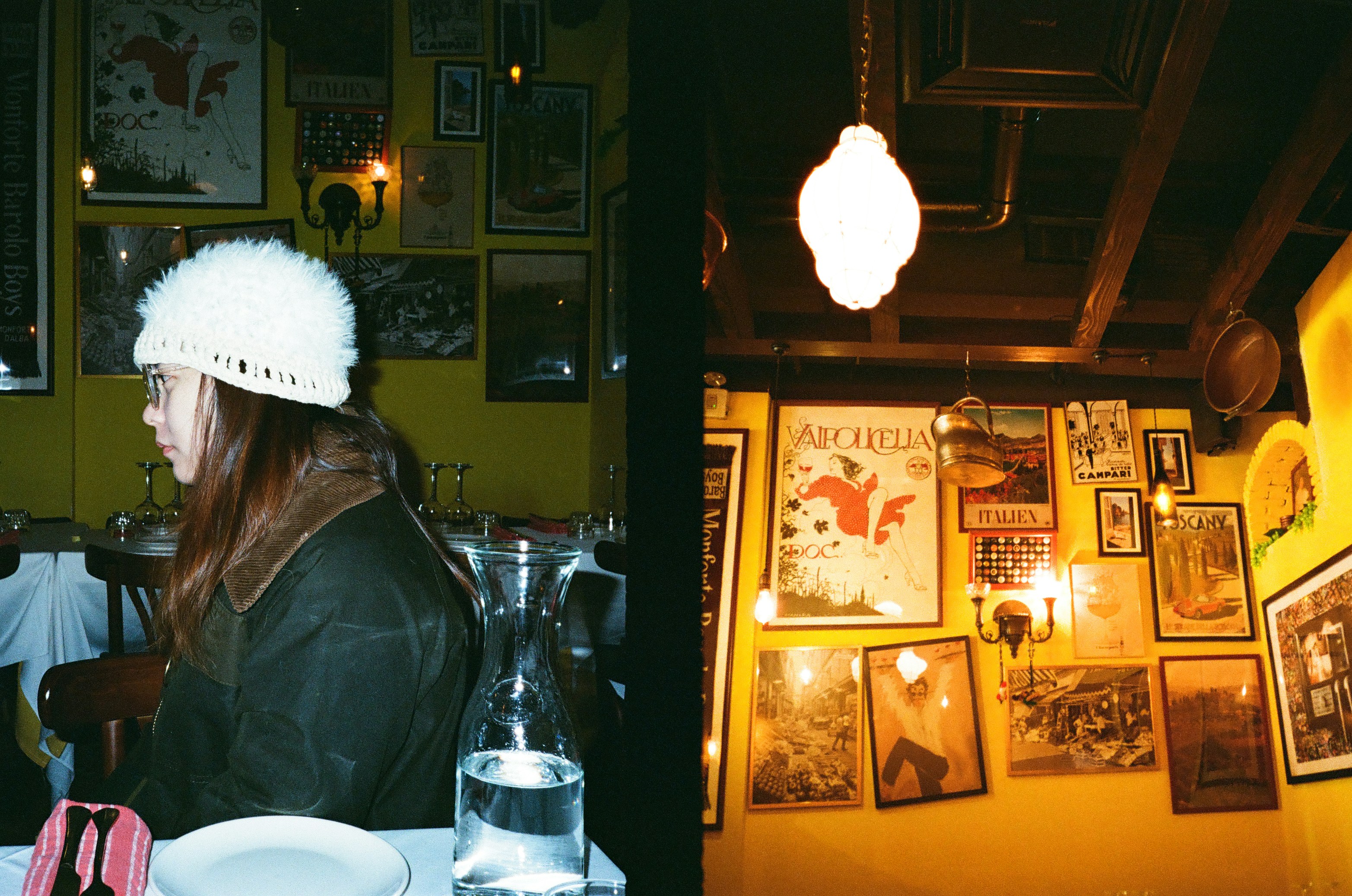 Woman in white hat at table with framed art