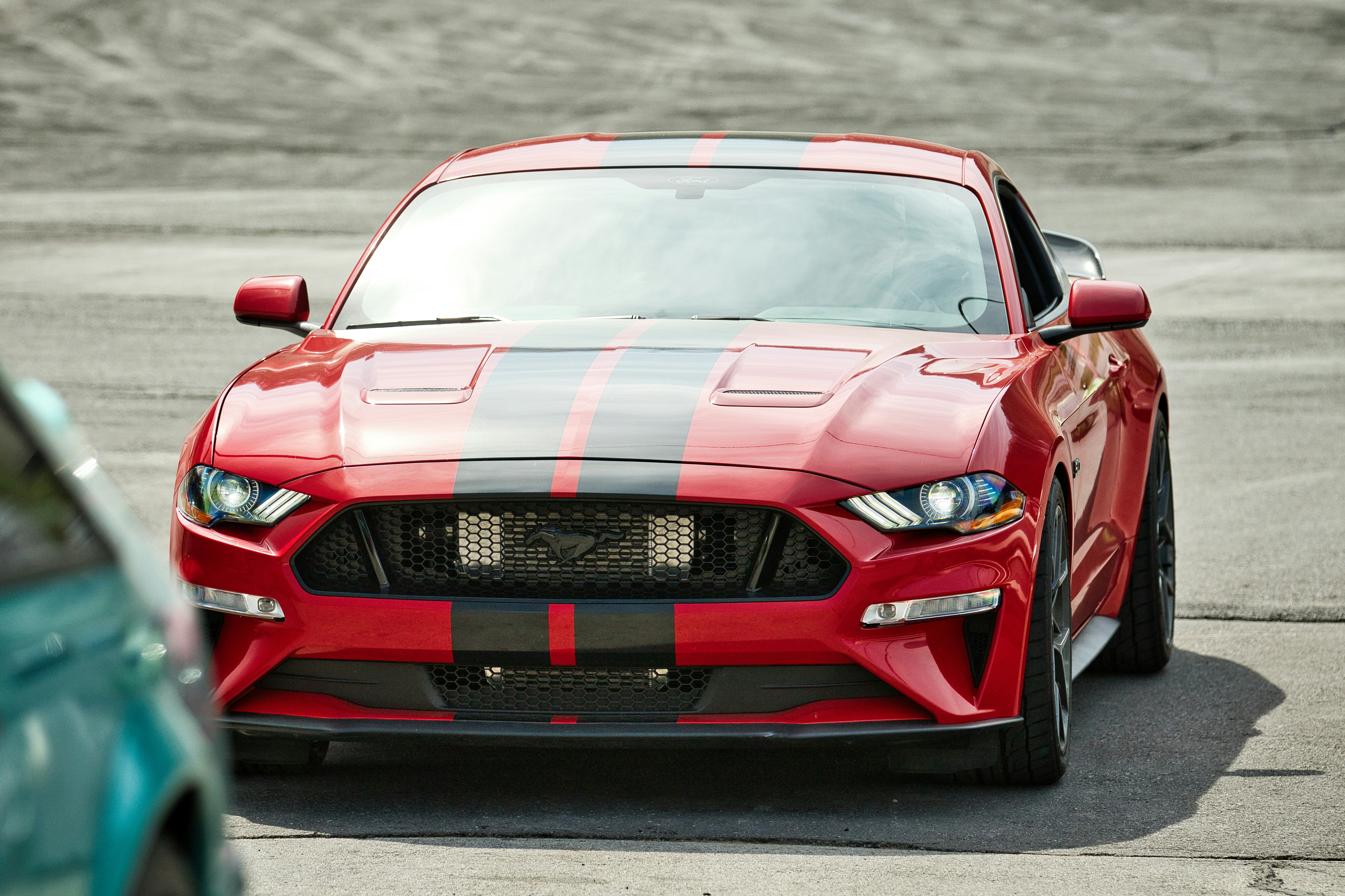 Coche deportivo rojo con franjas negras de competición en carretera