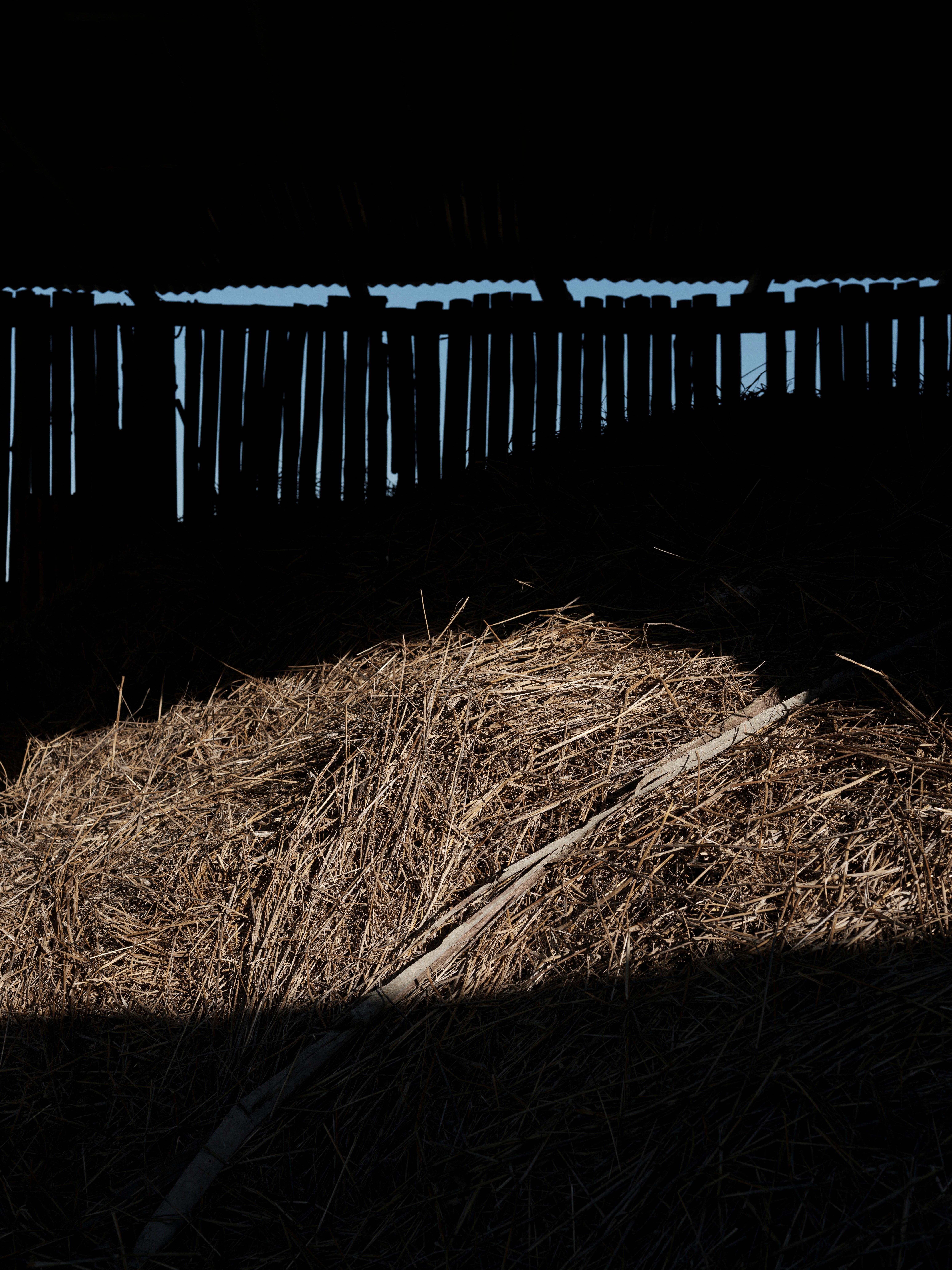 Pile of hay inside a dark barn