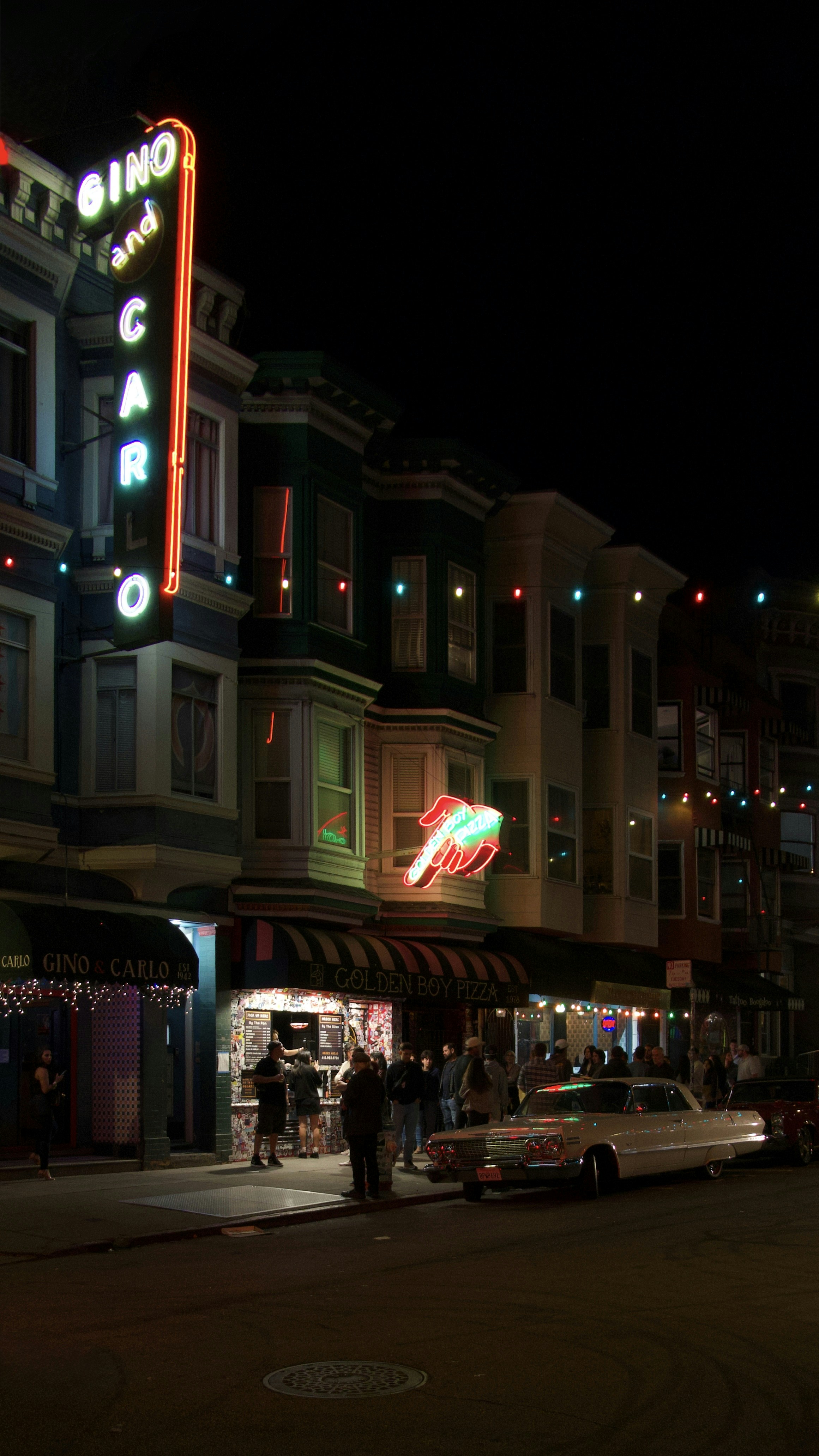 Neon sign lights up a street at night