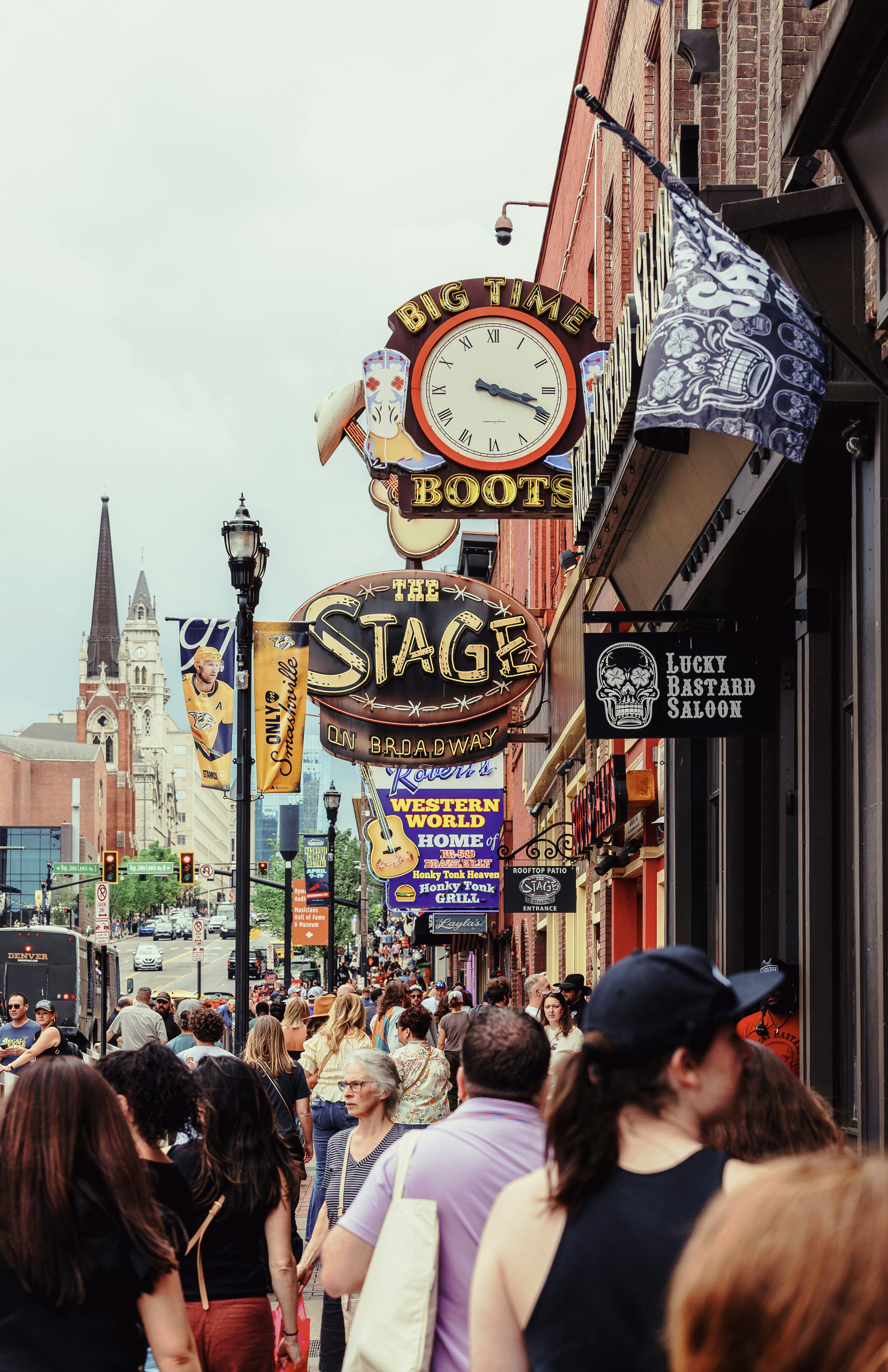 Crowded street with shops and signs, a lively city scene.