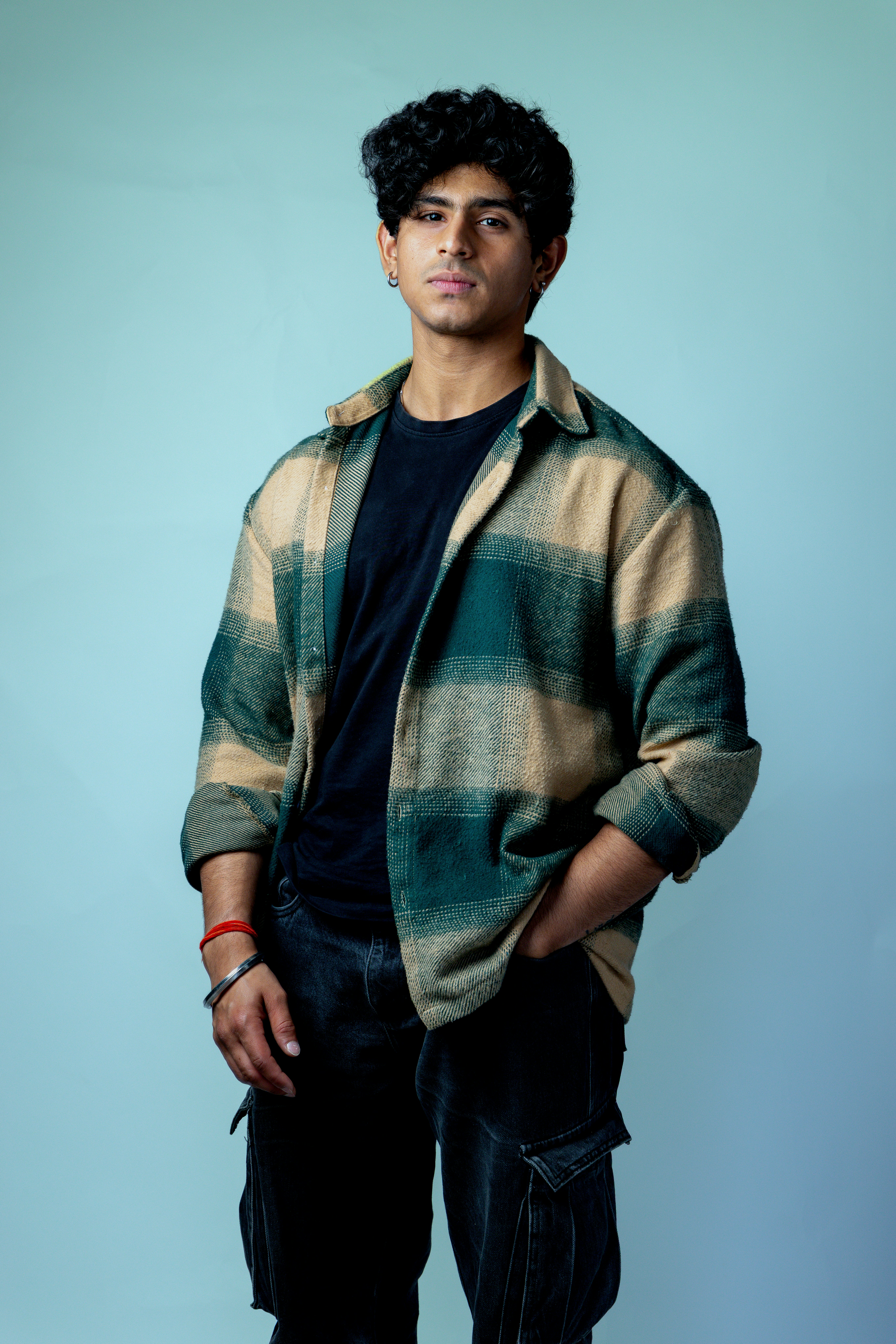 Young man with curly hair in plaid shirt