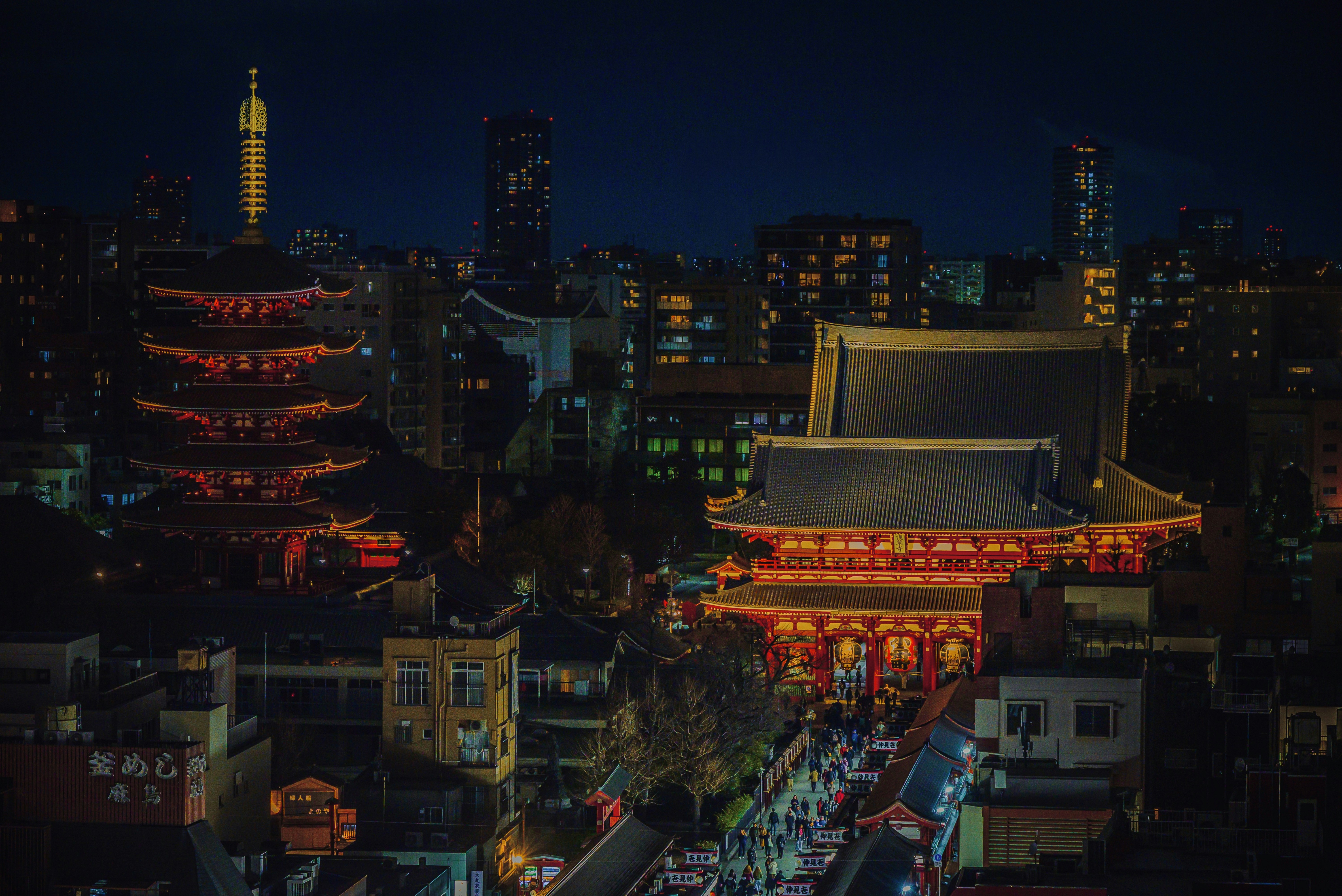 Traditional temple and pagoda illuminated at night.