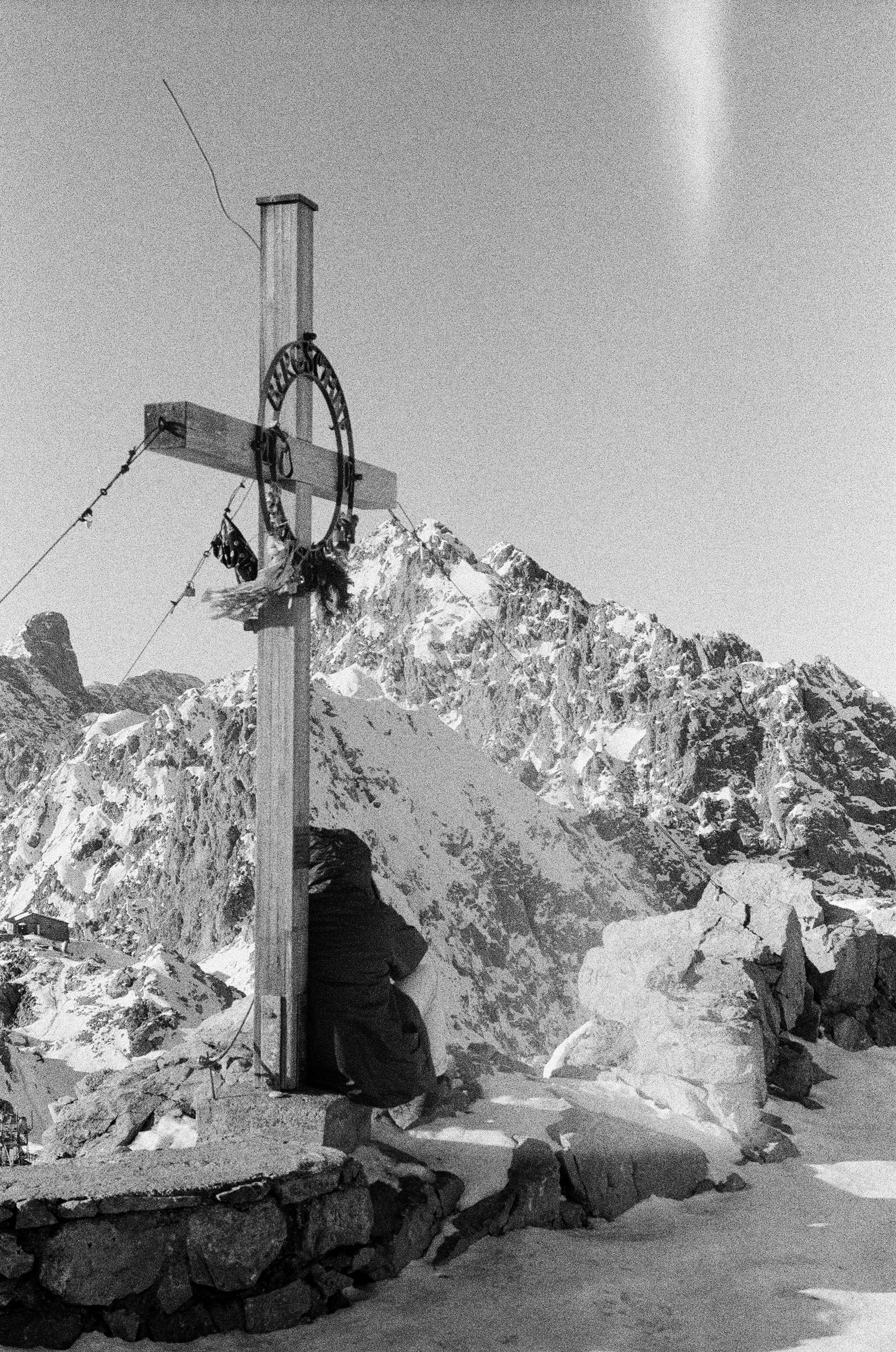 Cross with wreath on snowy mountain peak