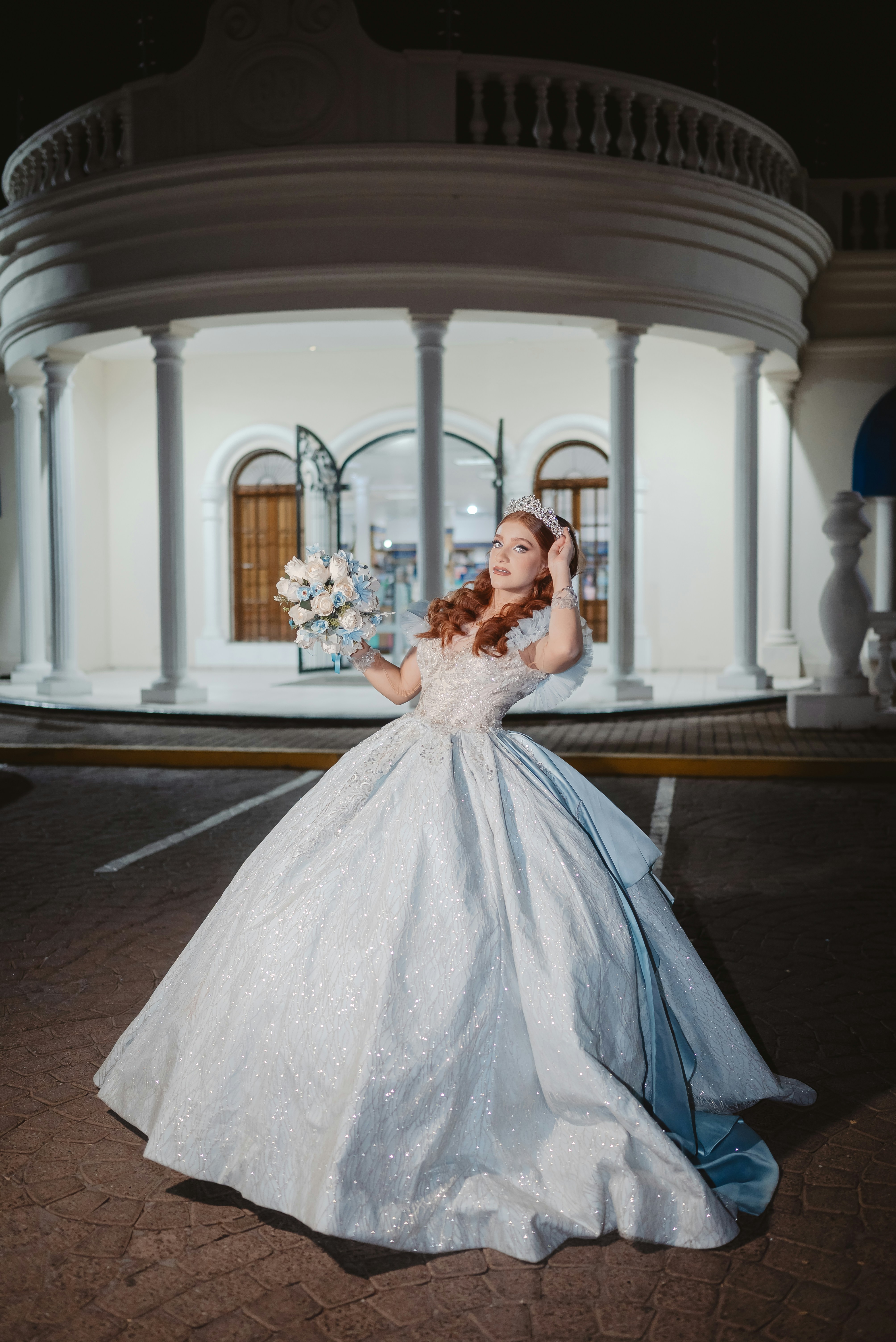 Young woman in a ball gown holding a bouquet outside