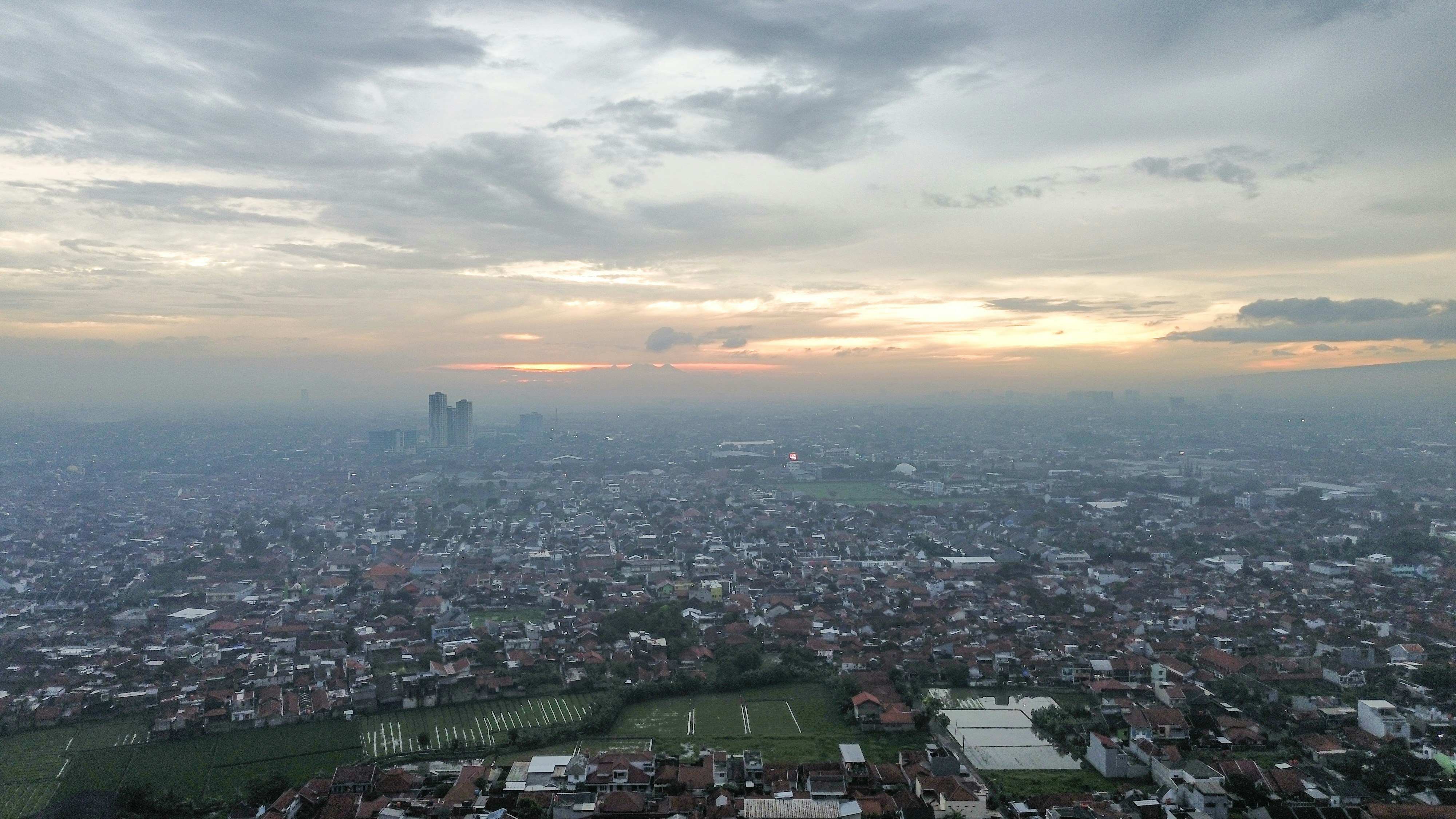 Paisagem urbana com prédios sob um céu nublado ao entardecer