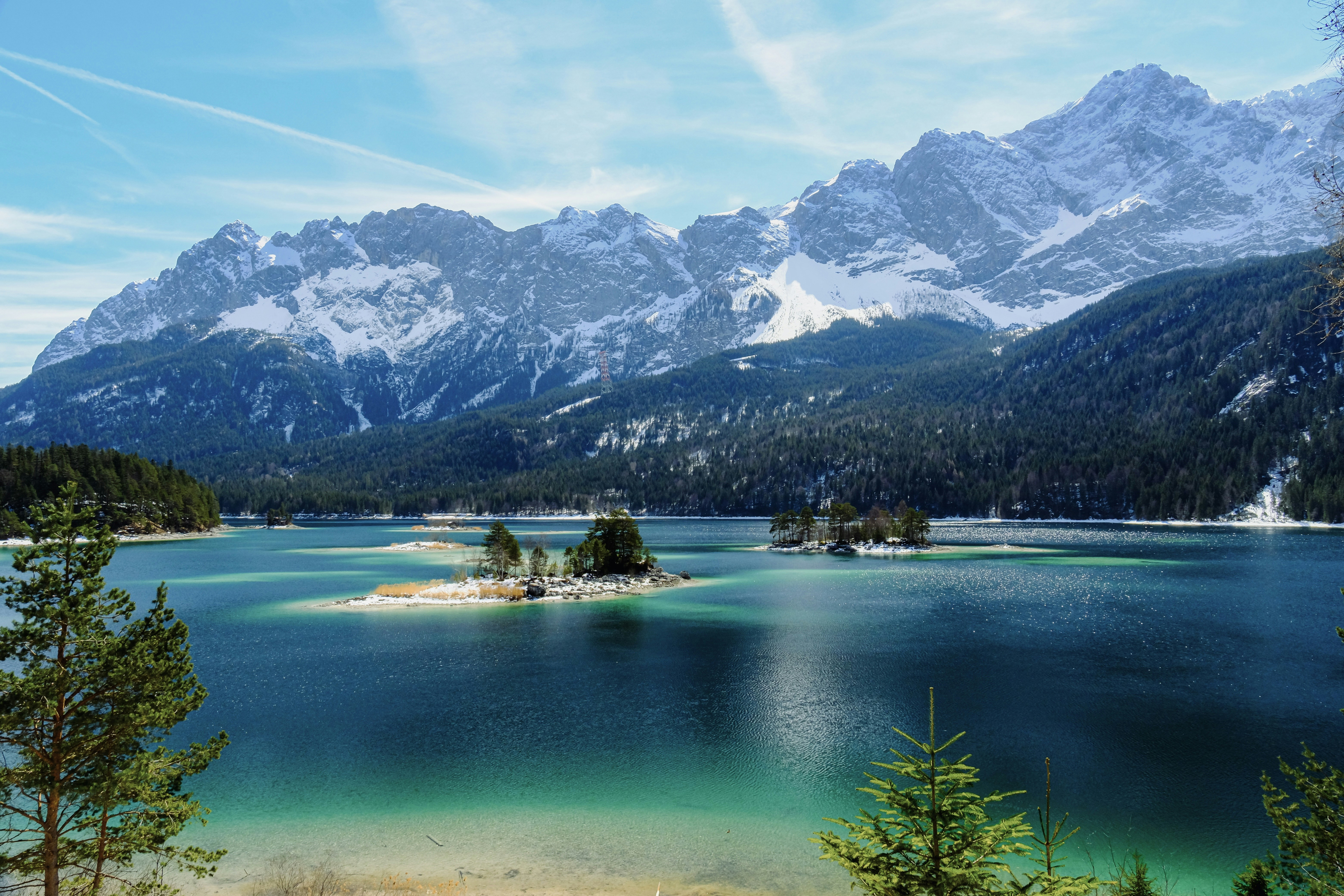 Lac turquoise avec des montagnes enneigées et des arbres persistants