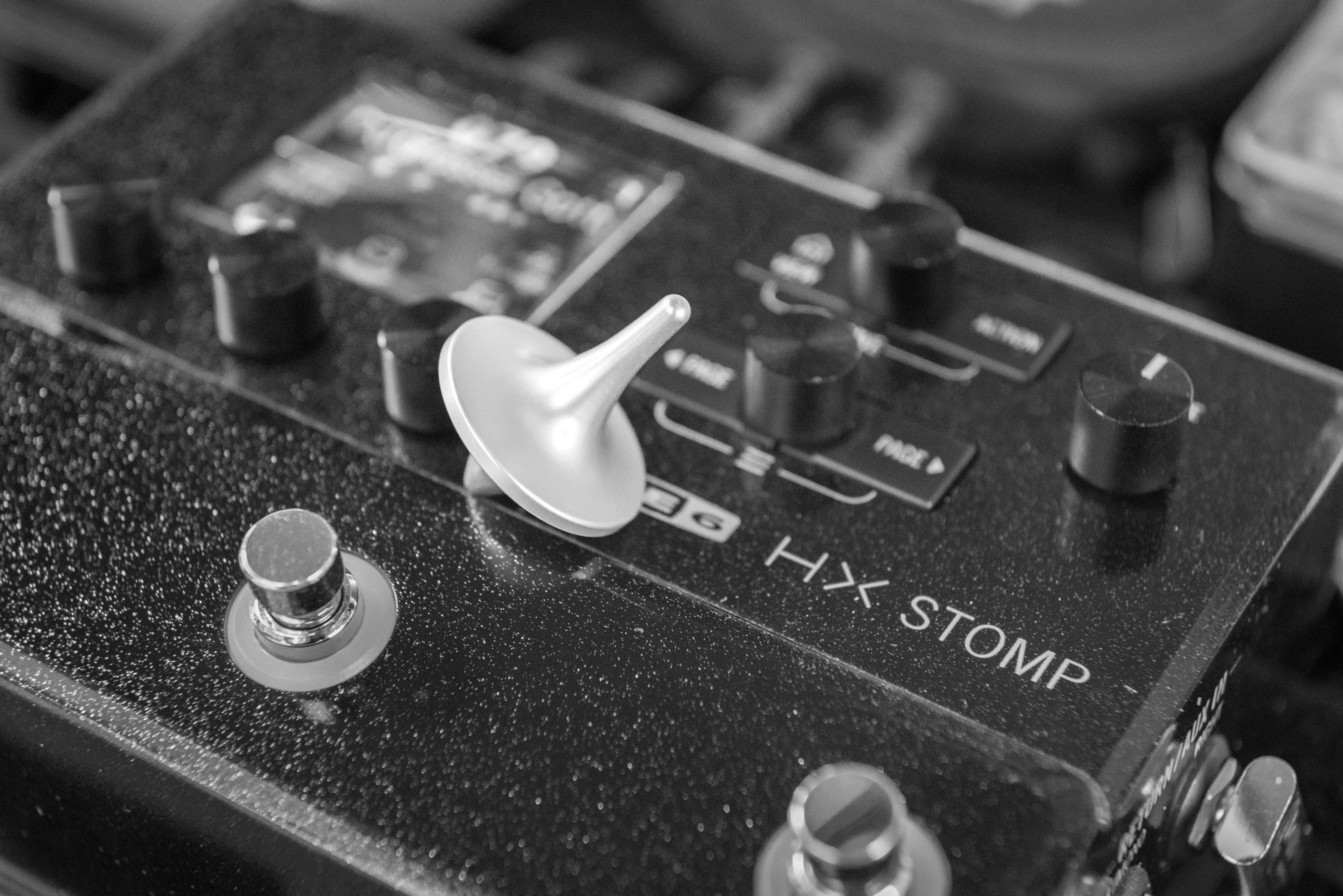A spinning top rests on a guitar effects pedal.