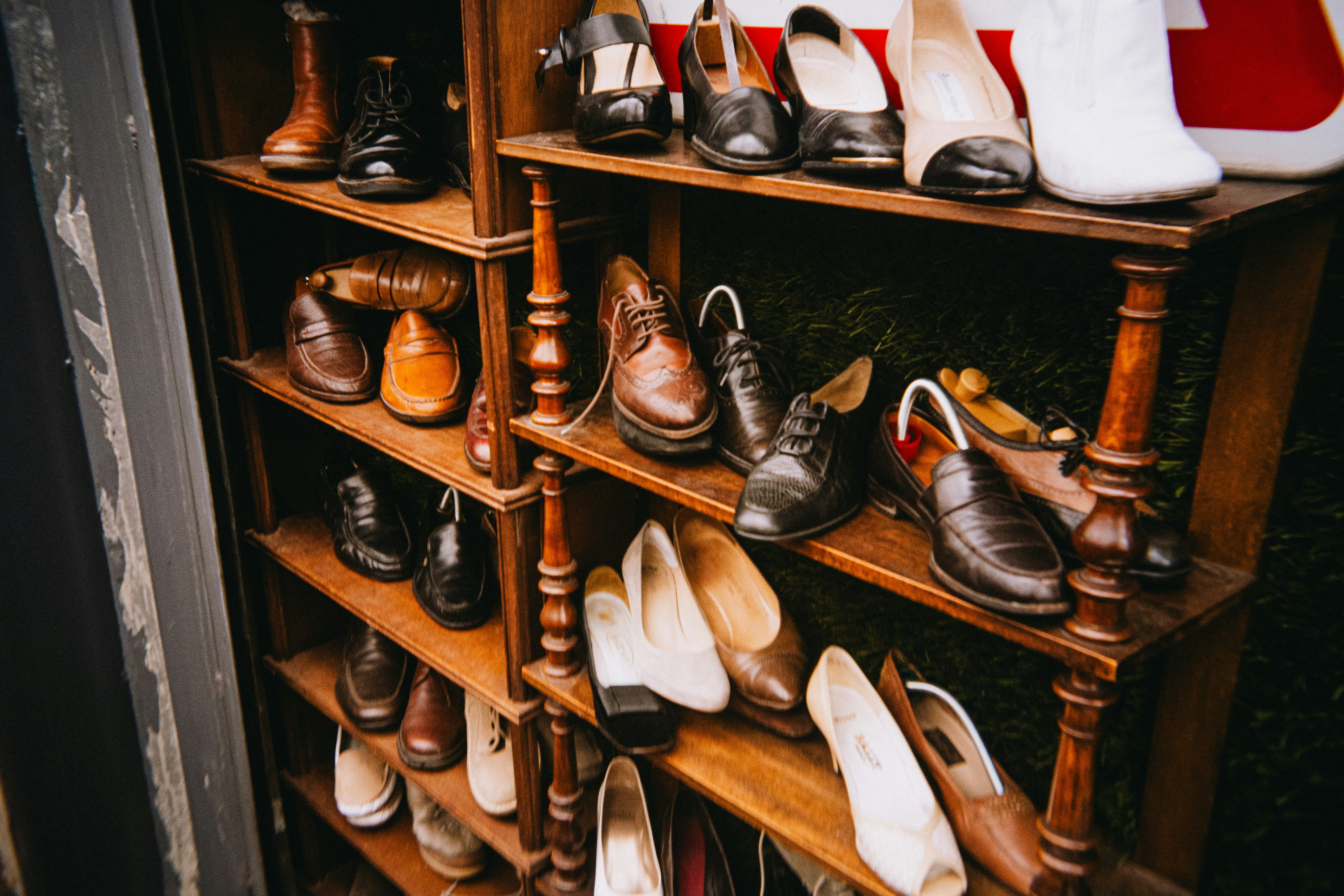 Various vintage shoes displayed on wooden shelves.