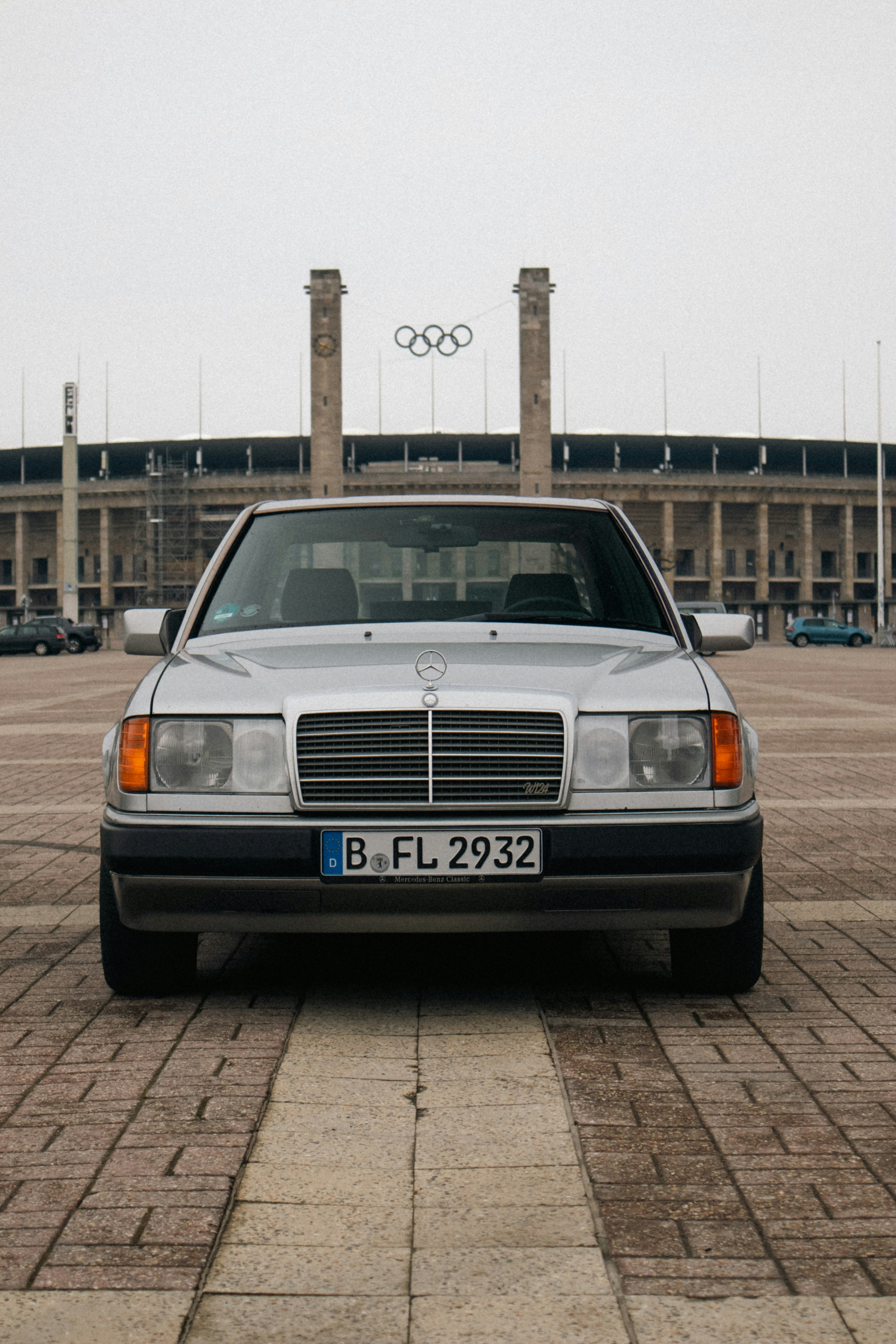 Silver mercedes-benz parked in front of stadium