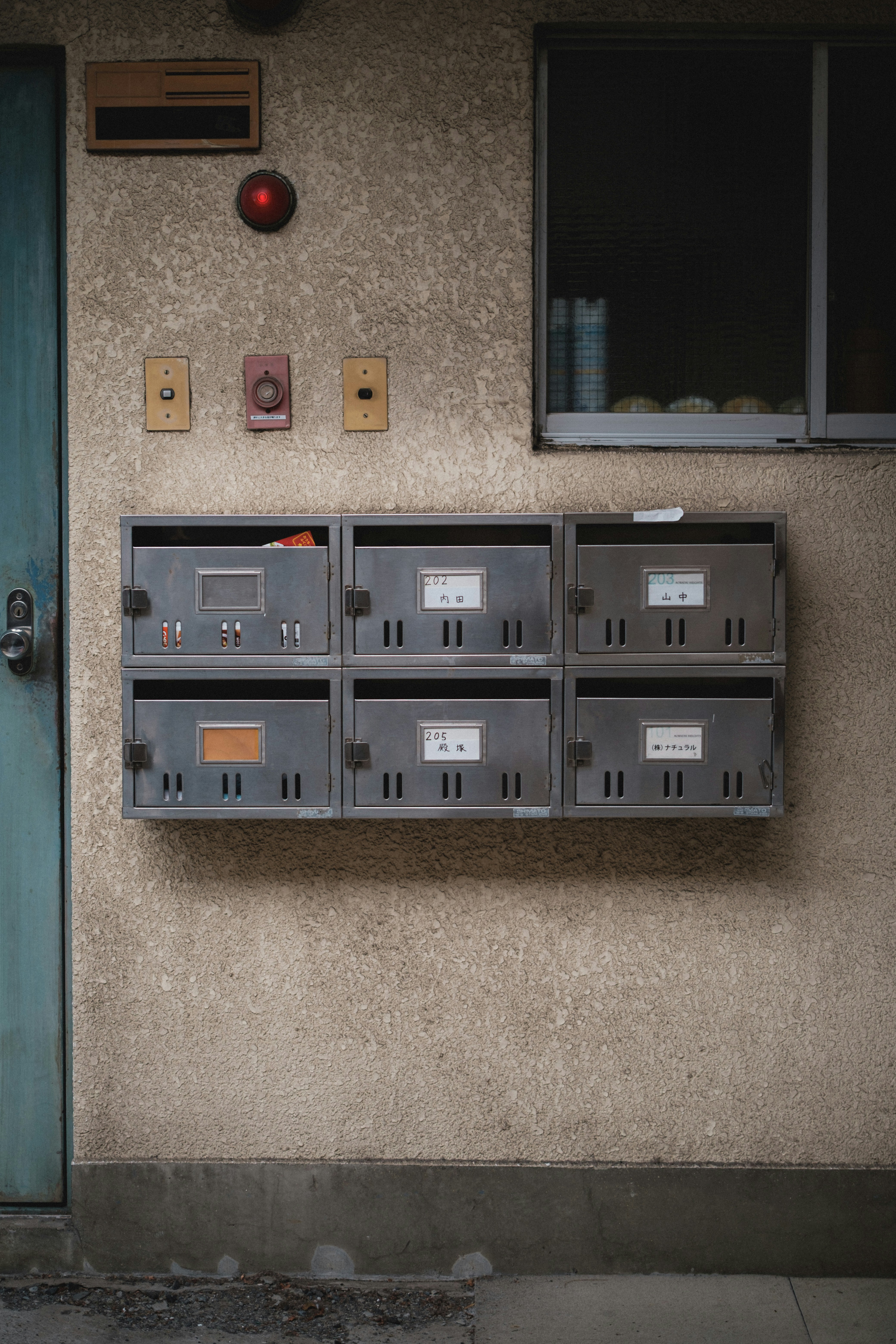 Sei cassette postali montate su una parete testurizzata.