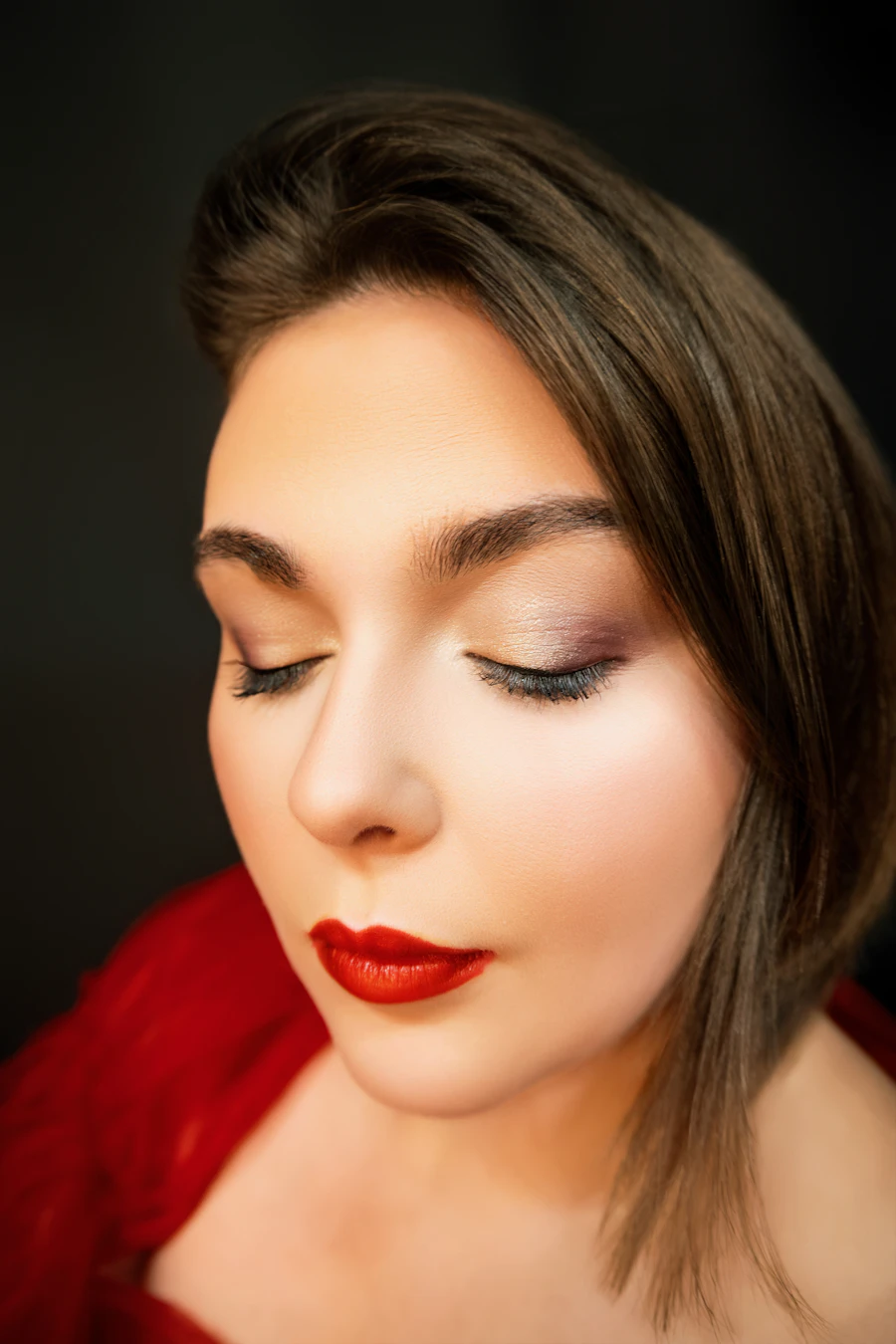 Editorial beauty portrait with closed eyes and red lipstick