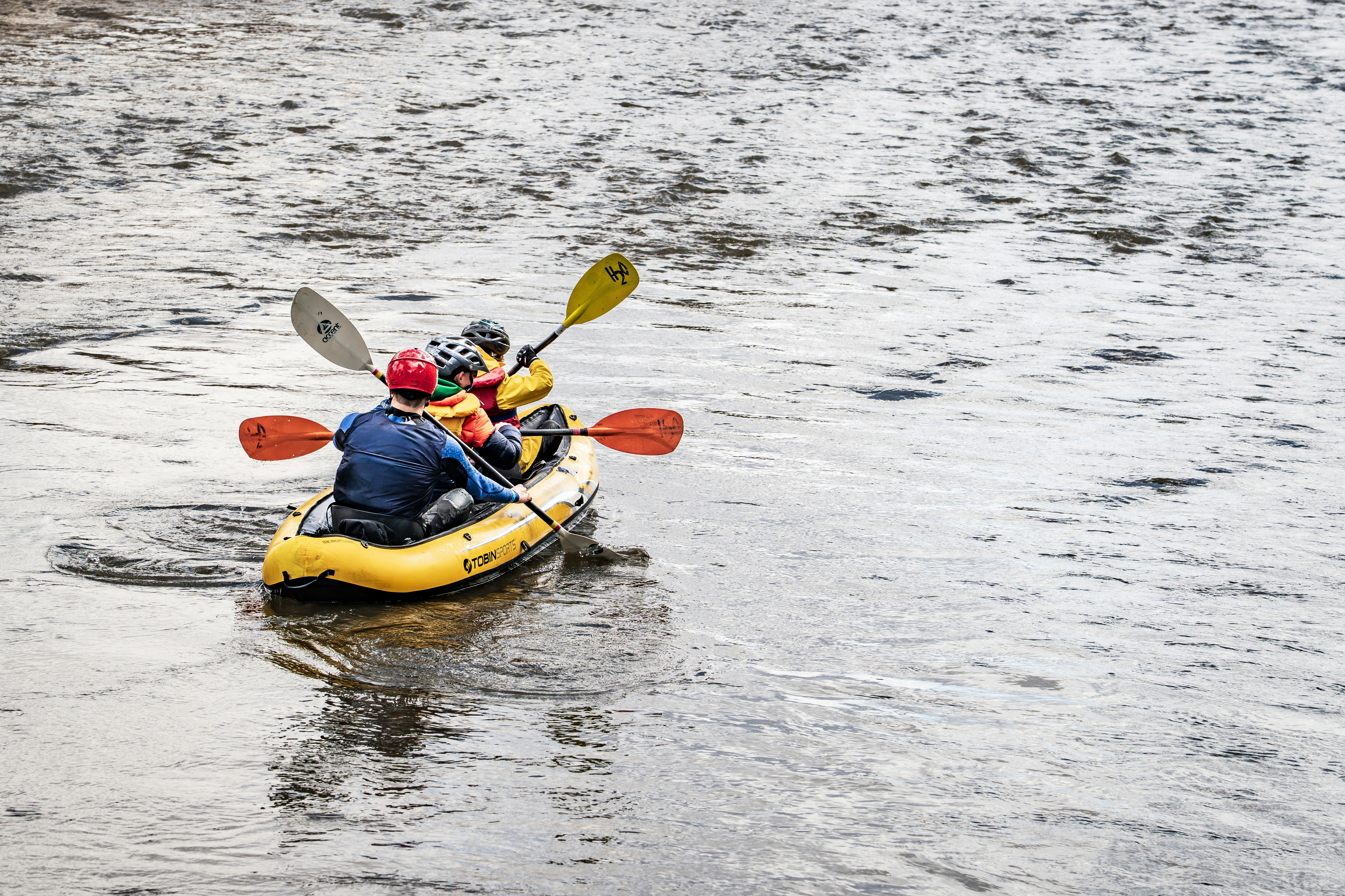 Two people in a yellow raft paddling on a river