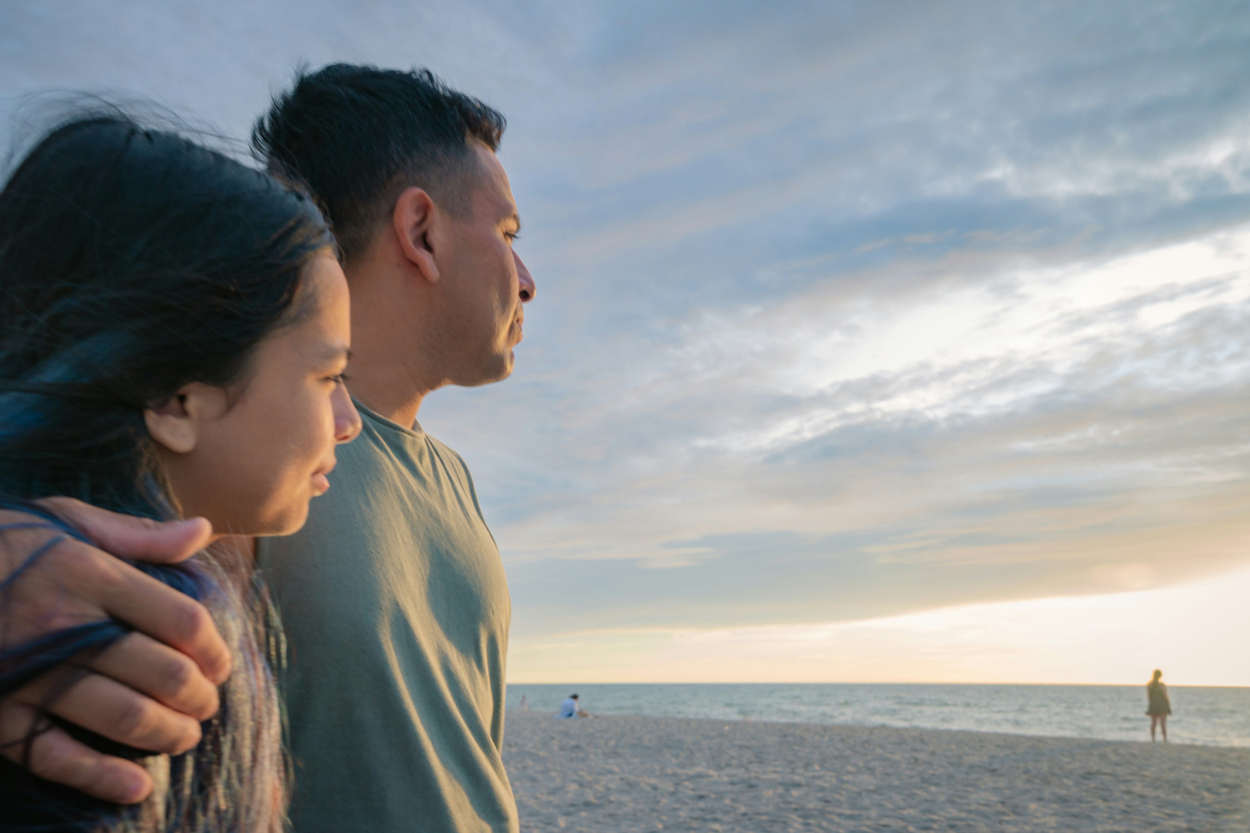 Couple looking at the ocean at sunset