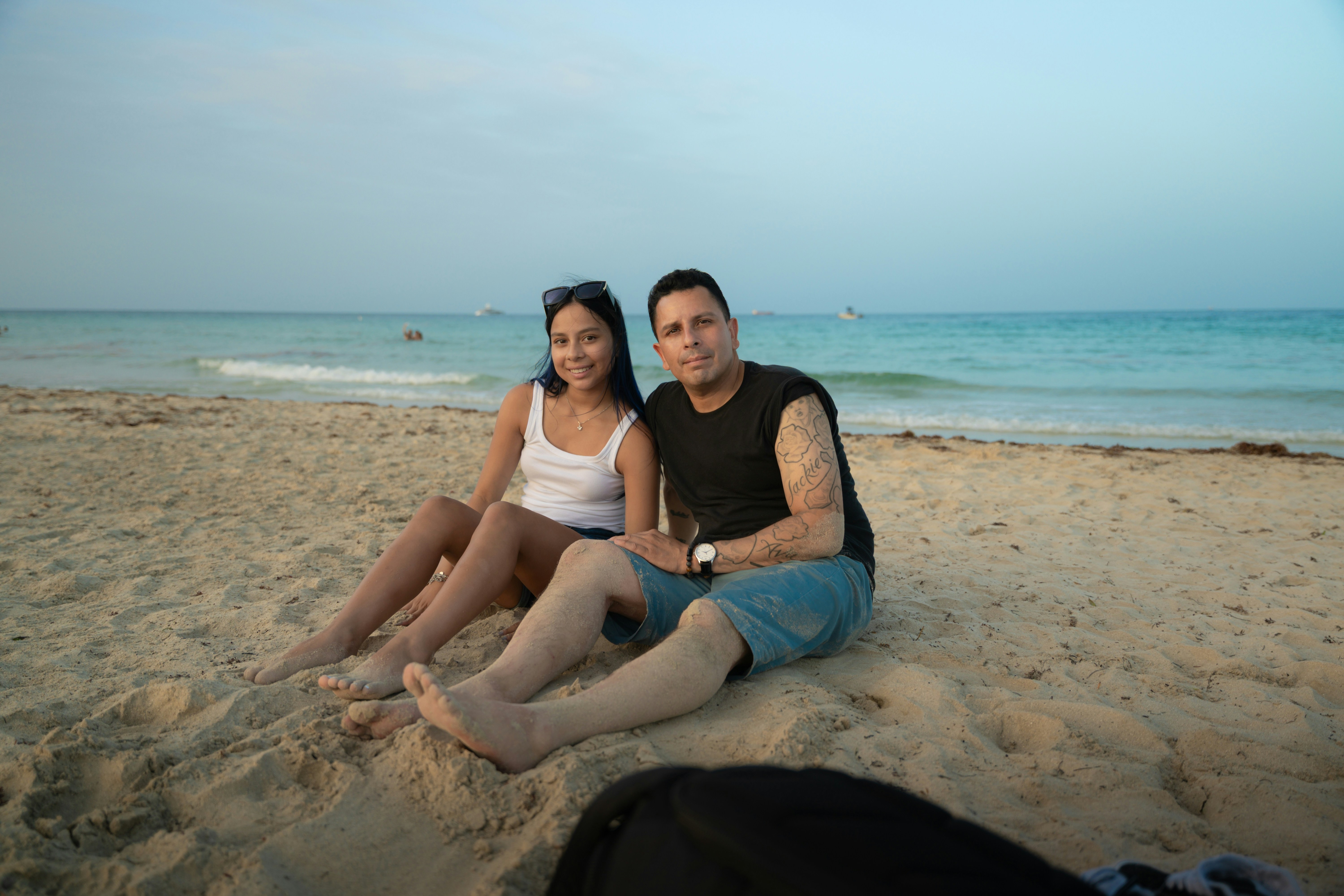 Couple relaxing on a sandy beach by the ocean.