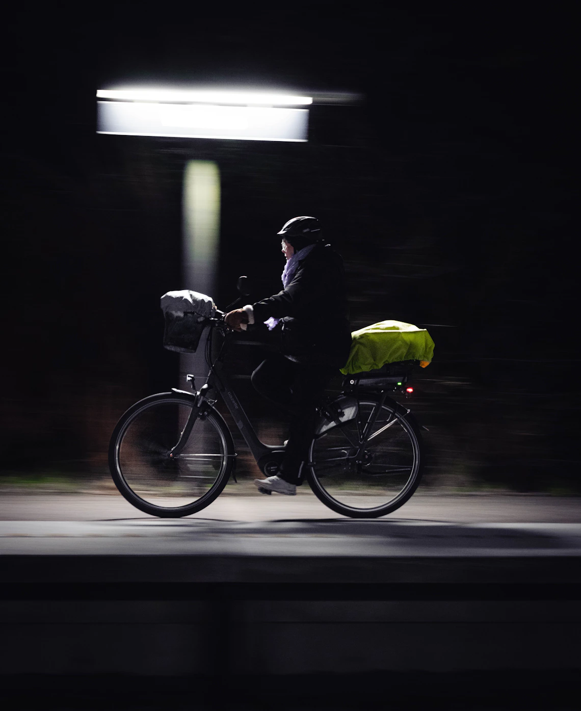 Cyclist moving through the city at night with motion blur