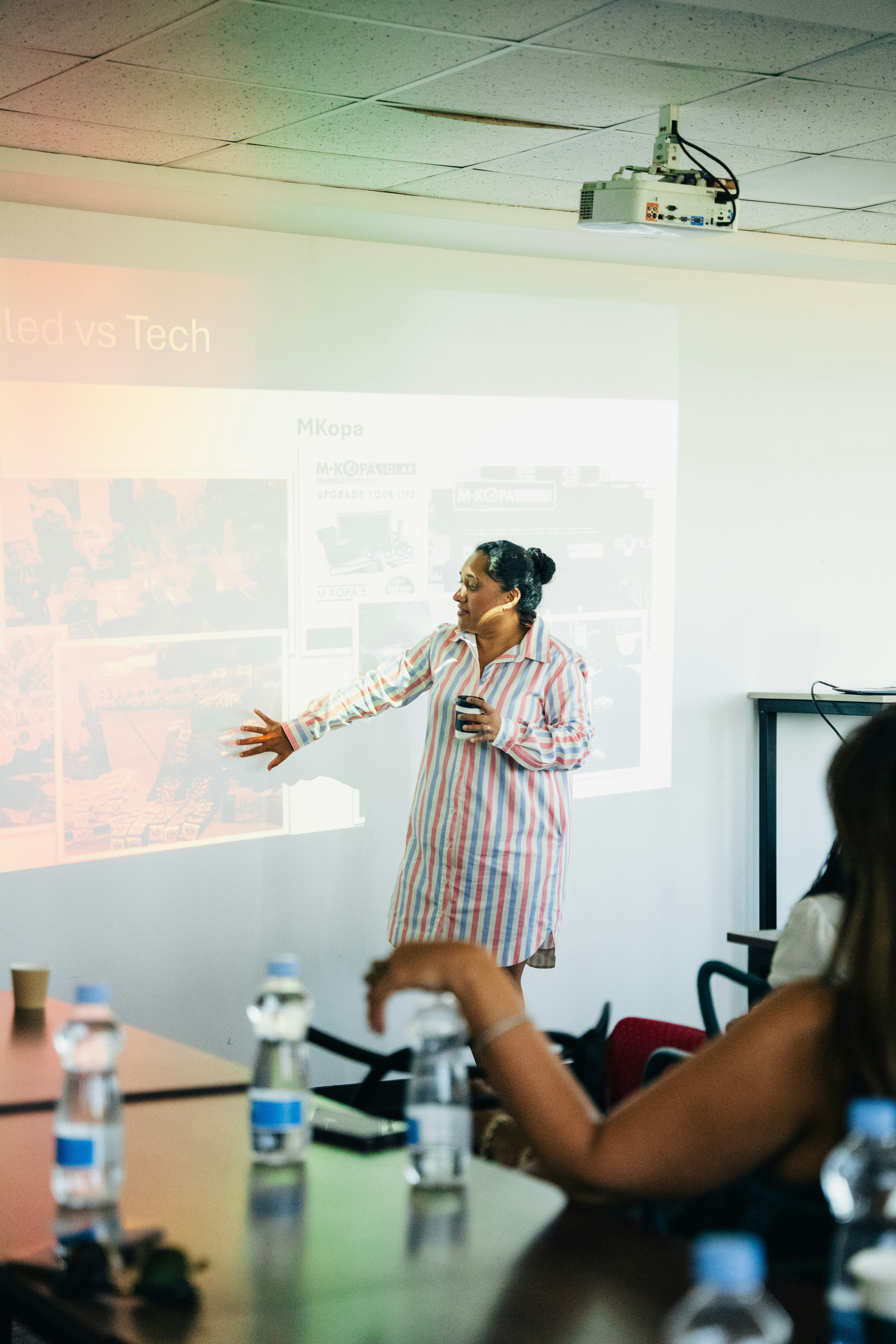 Femme présentant devant le public près de l’écran du projecteur.