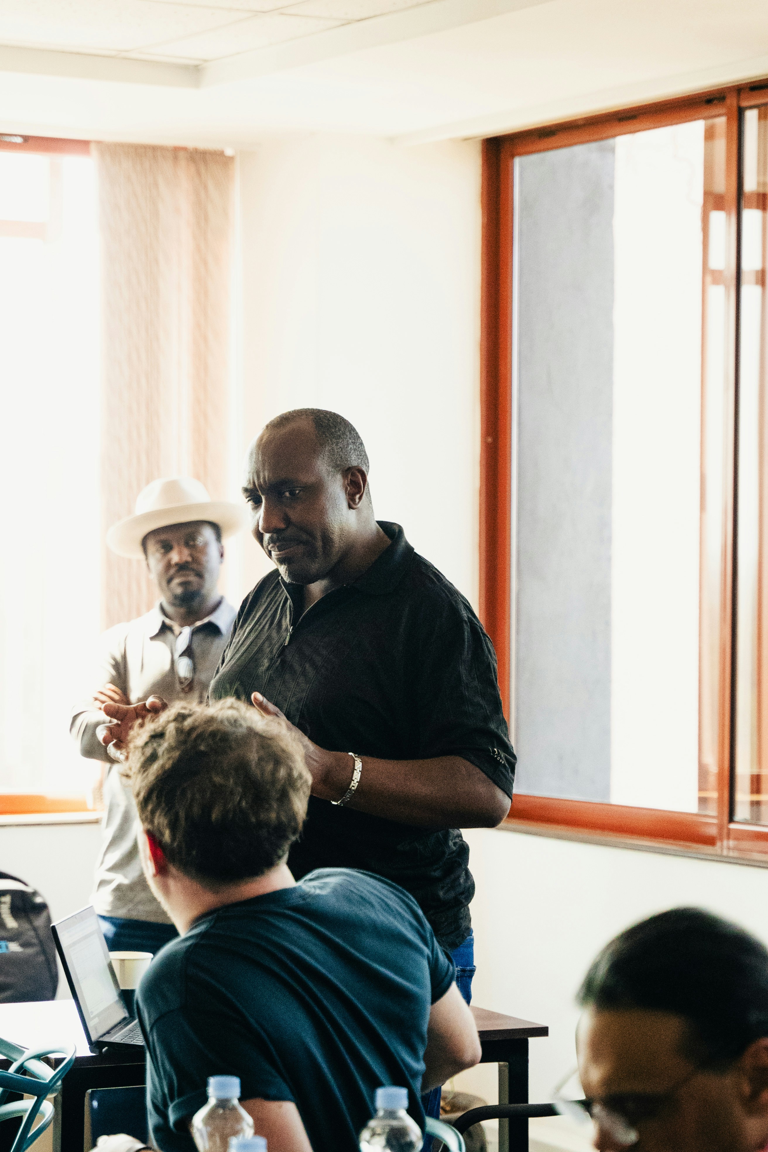 Des hommes dans une salle de réunion avec des ordinateurs portables et des bouteilles d’eau.