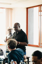 Men in a meeting room with laptops and water bottles.