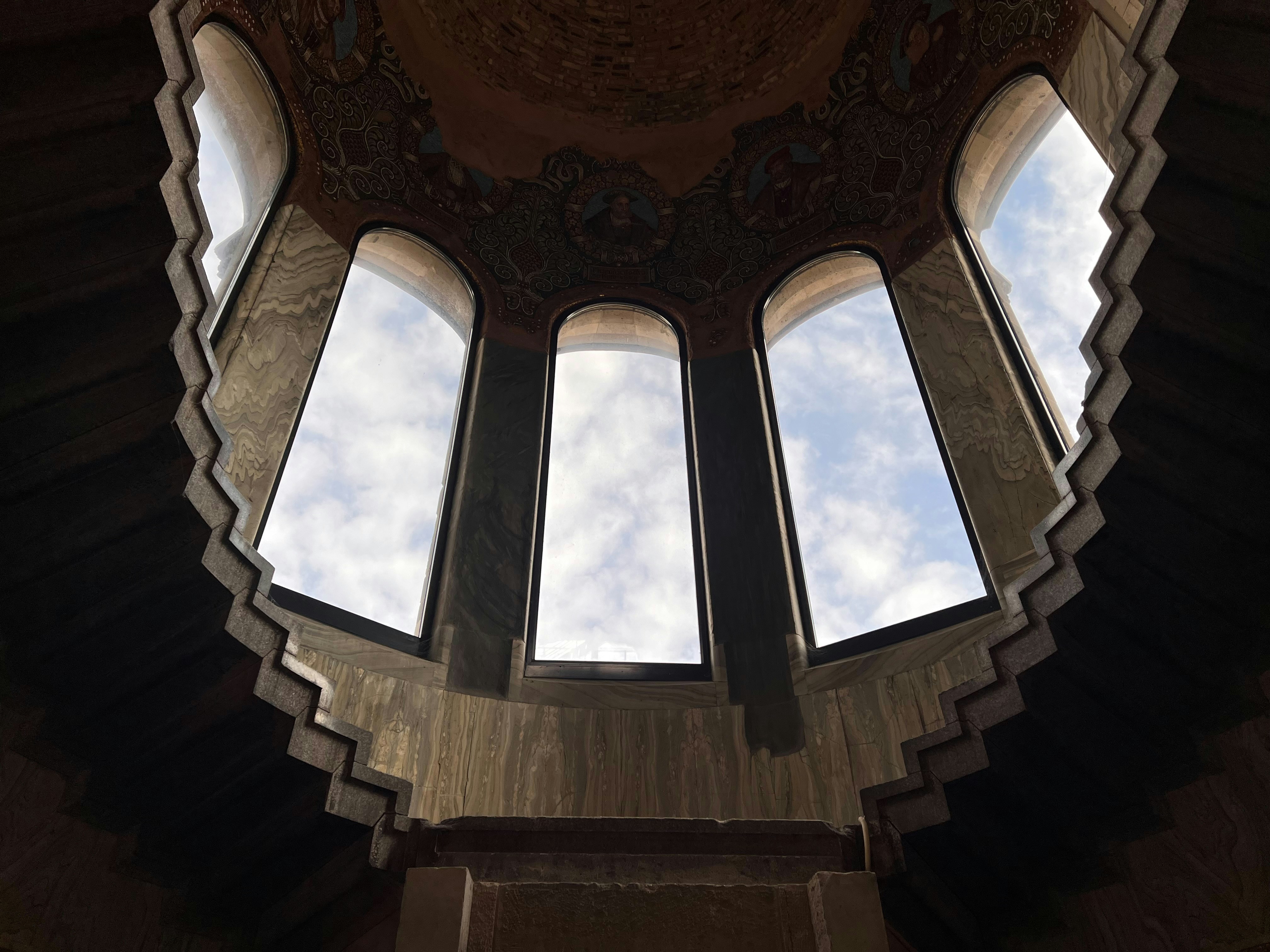 Arched windows in a domed structure revealing sky