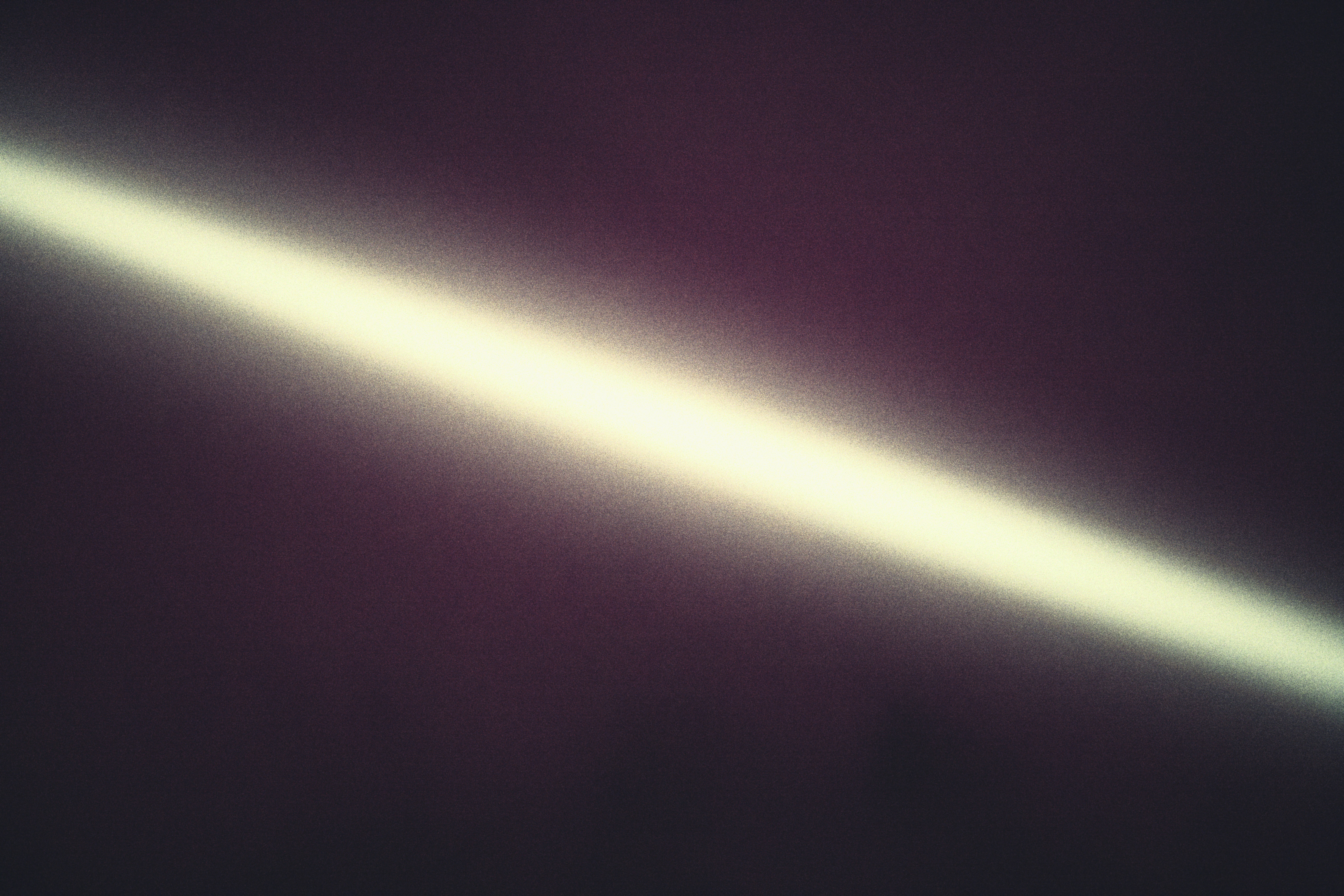 Berkas cahaya terang secara diagonal melintasi latar belakang gelap