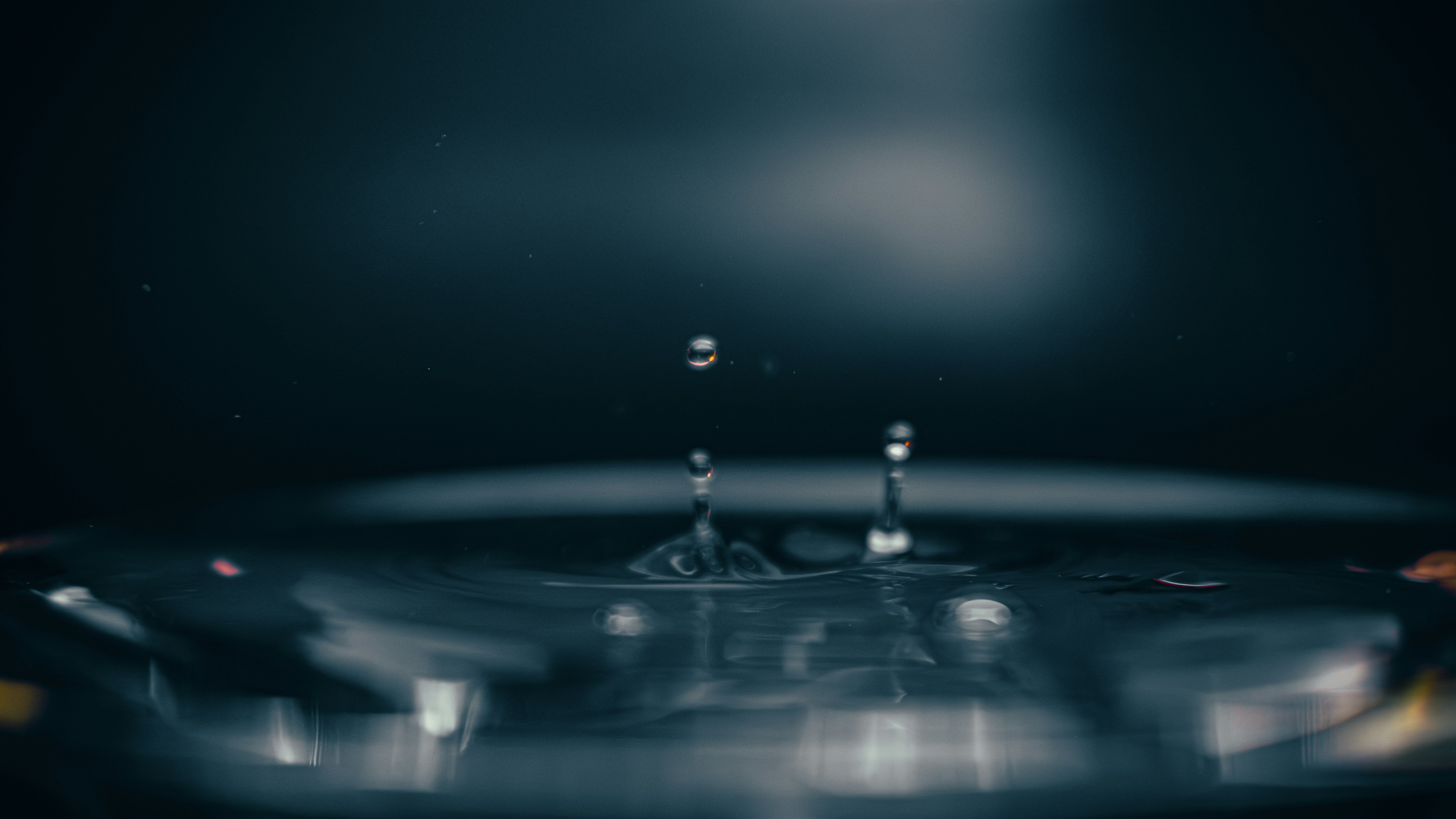 Wassertropfen, die auf eine ruhige Oberfläche fallen