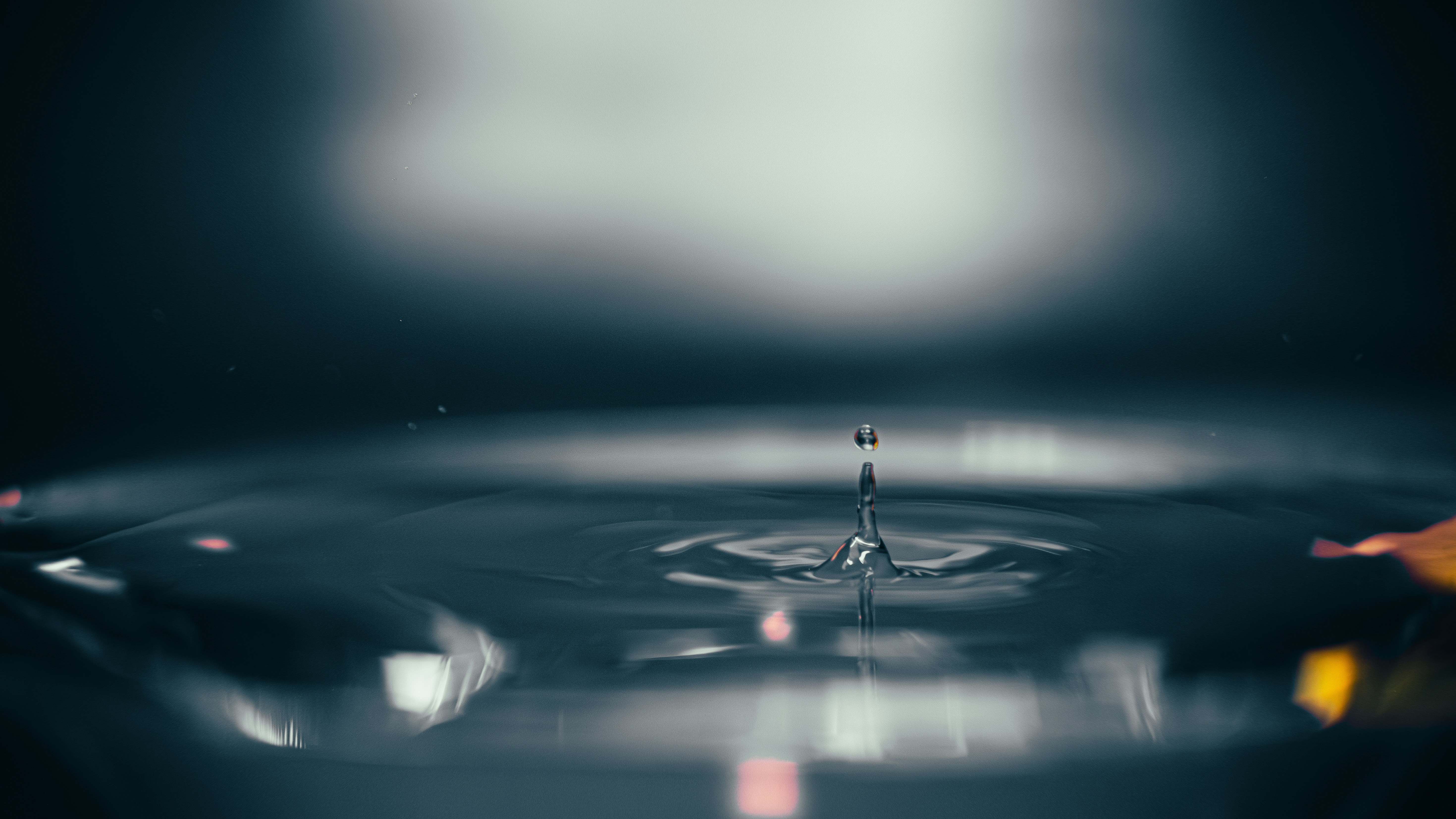 Ein Wassertropfen, der in ruhiges Wasser fällt