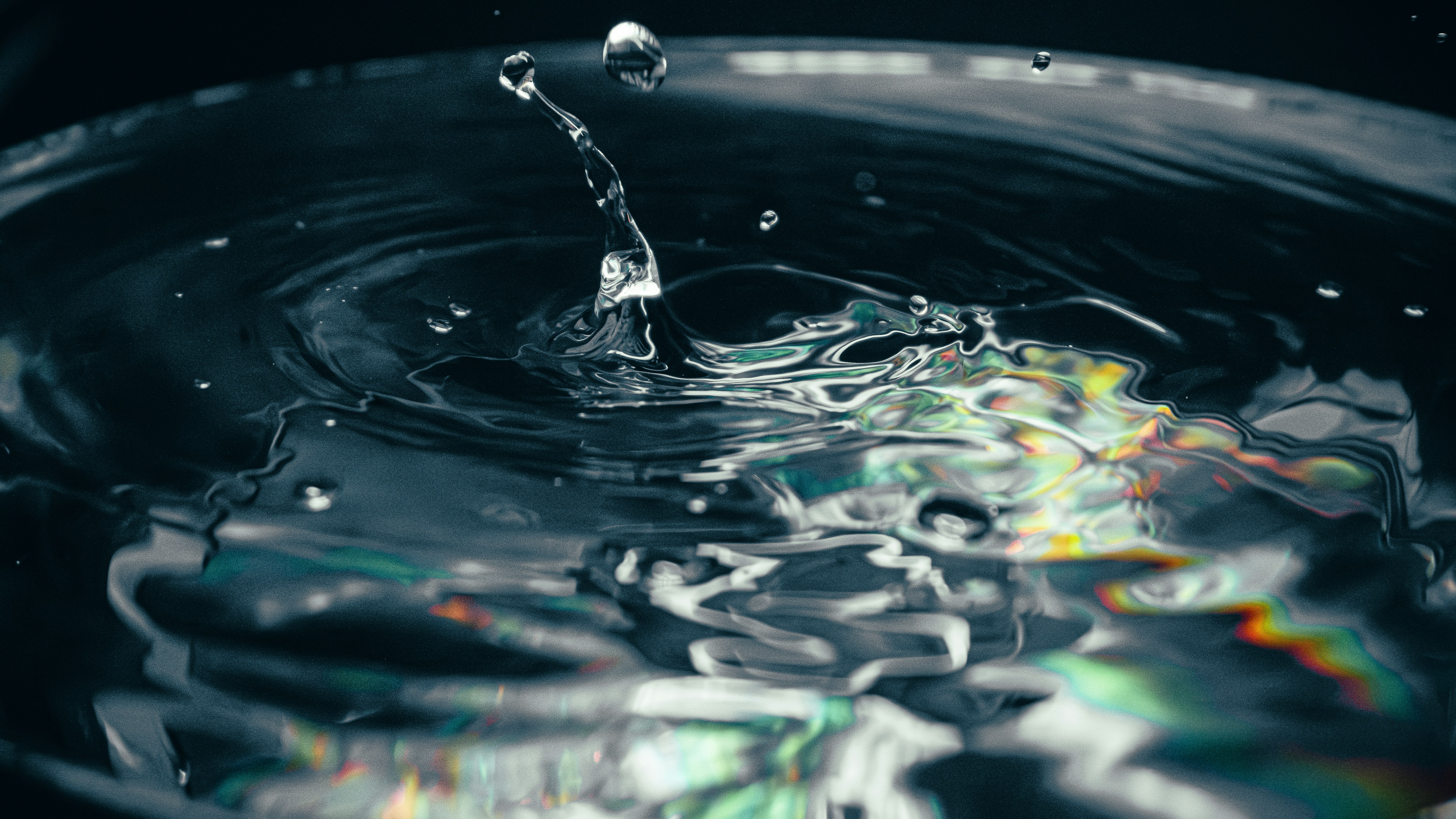 Ein Wassertropfen, der ins klare Wasser fällt und Wellen verursacht