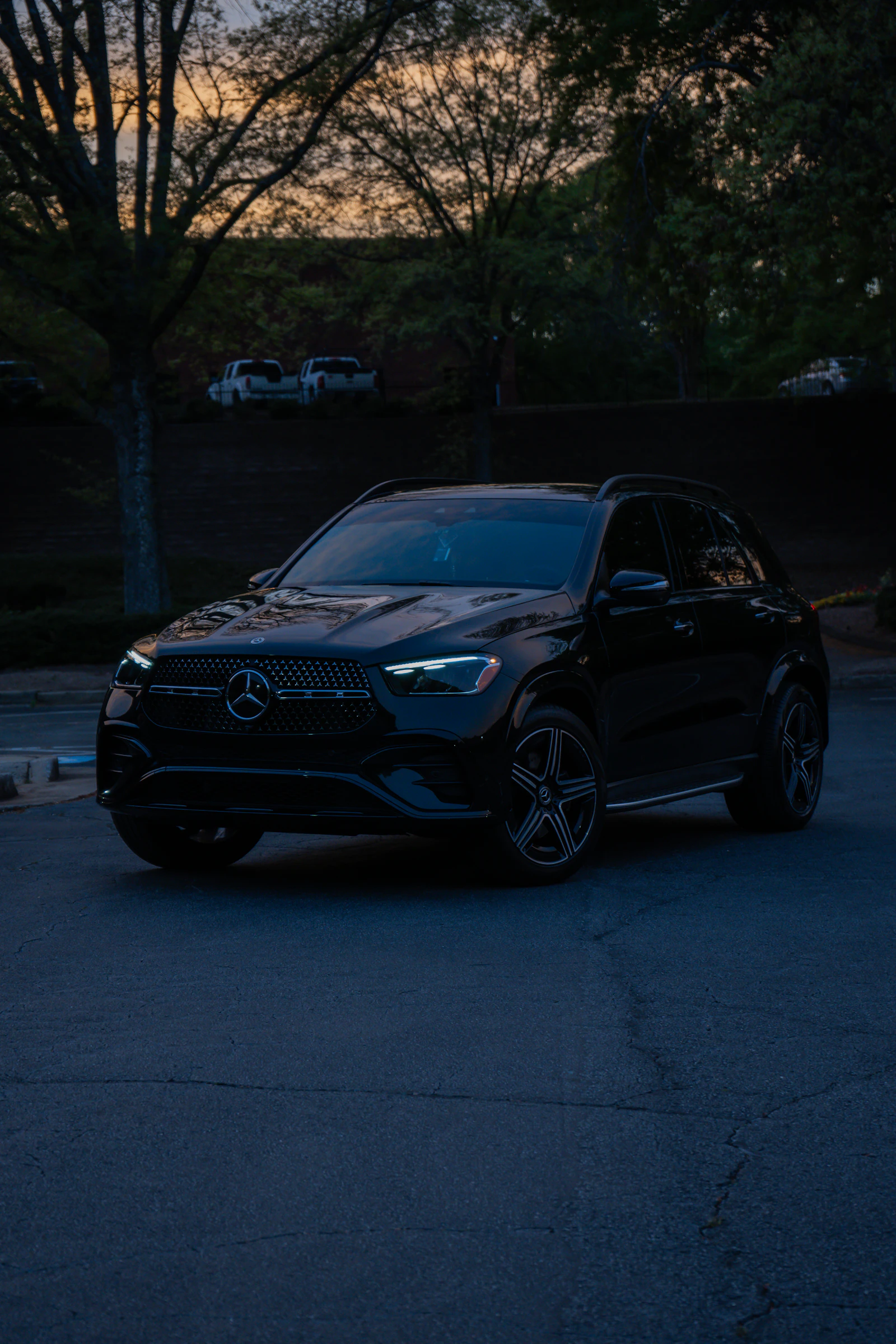 A black executive SUV parked outdoors at dusk, ready for discreet secure transport