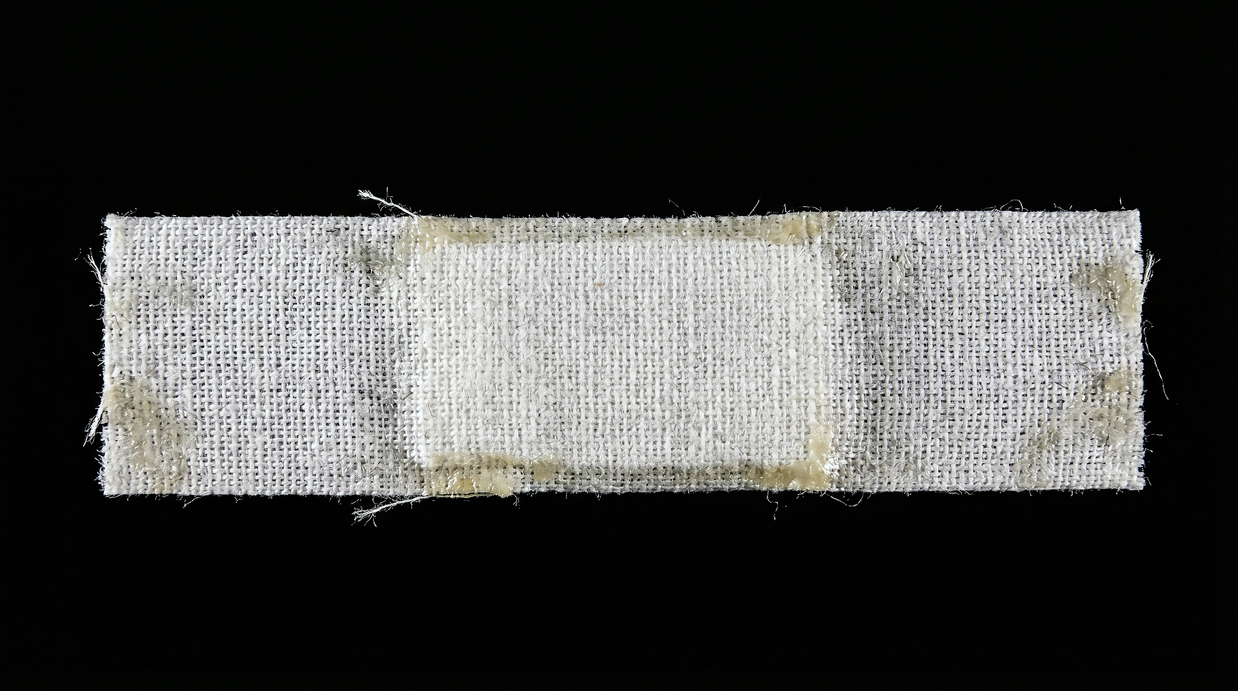 A dirty white fabric bandage on black background