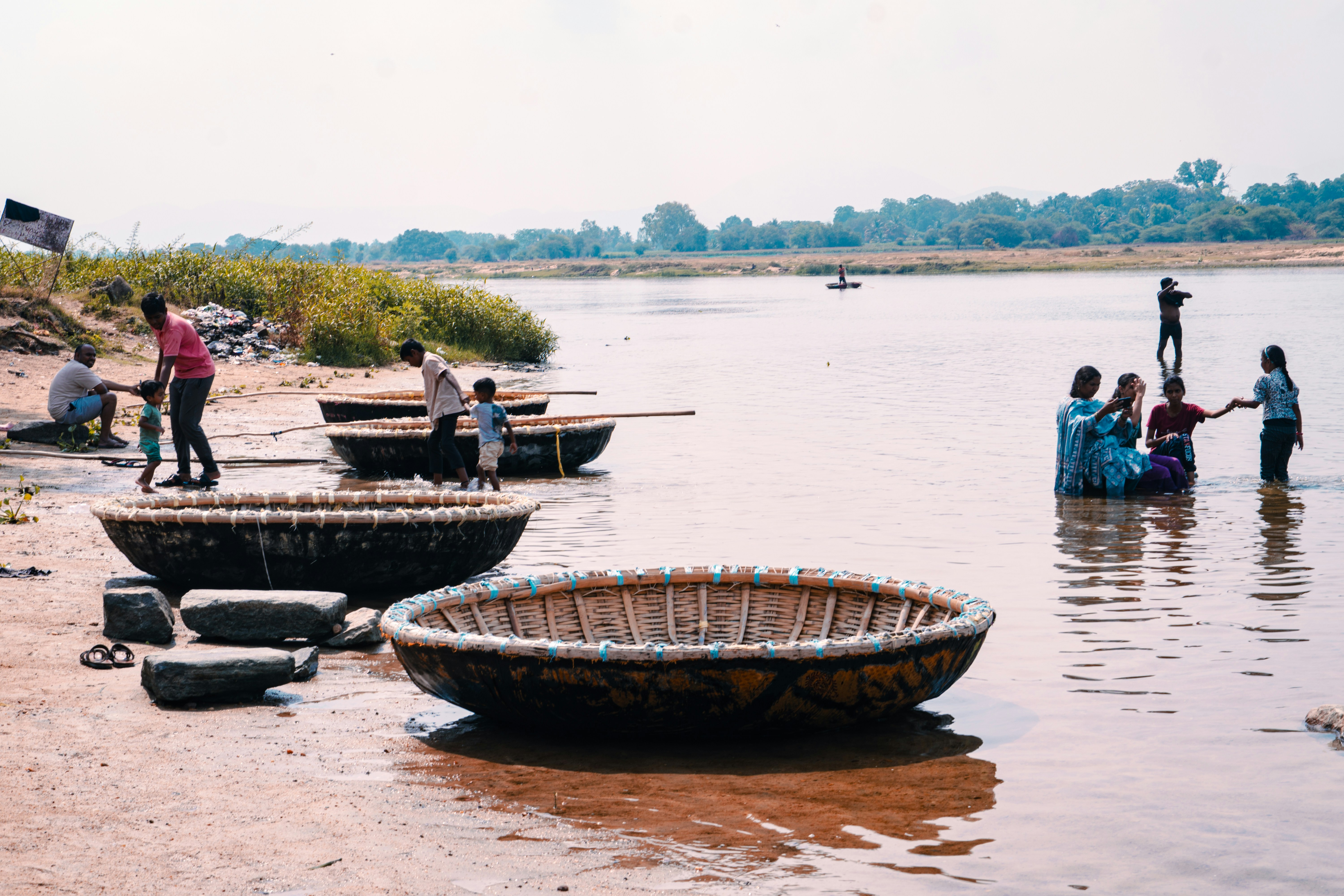 人々は伝統的なバスケットボートで川辺に集まります。
