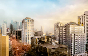 Modern city skyline with tall buildings under a cloudy sky.