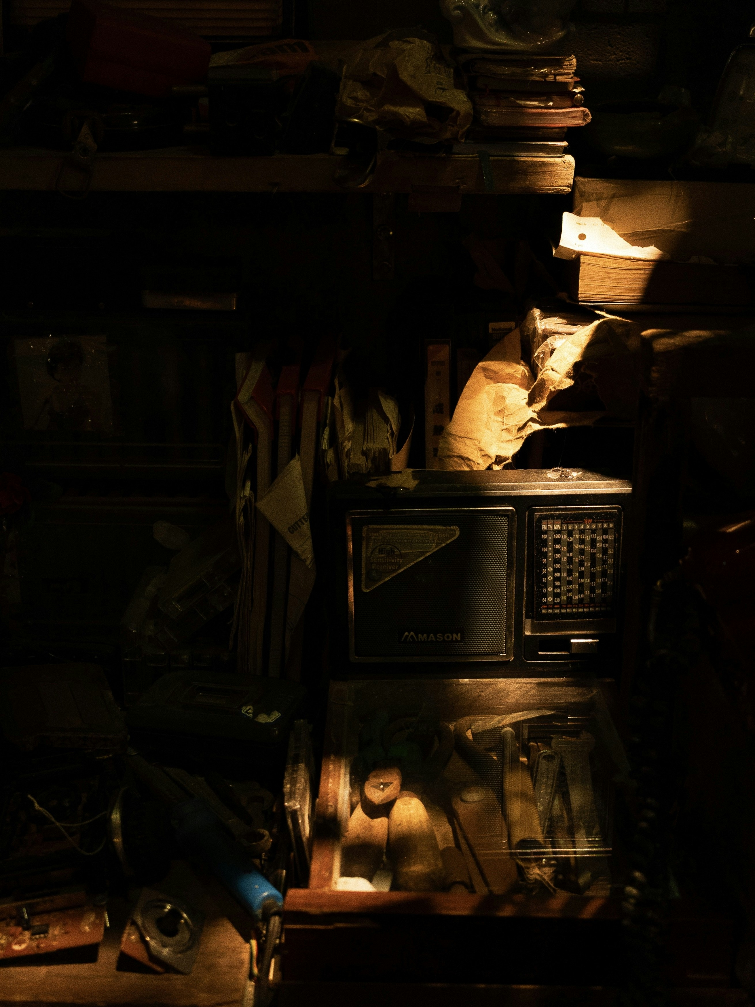 Radio antik duduk di rak dengan barang-barang.
