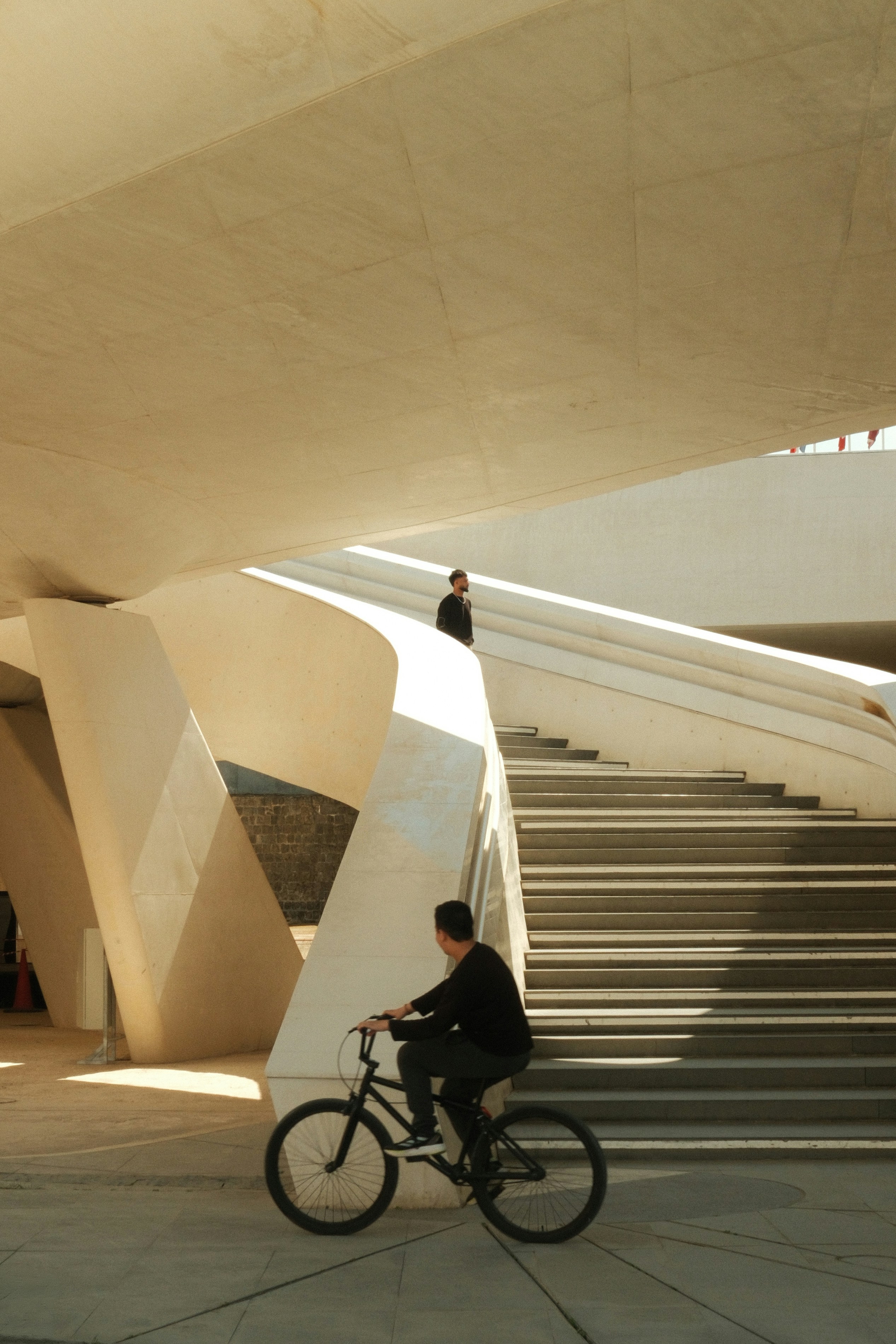 Pria di atas sepeda di dekat tangga beton modern