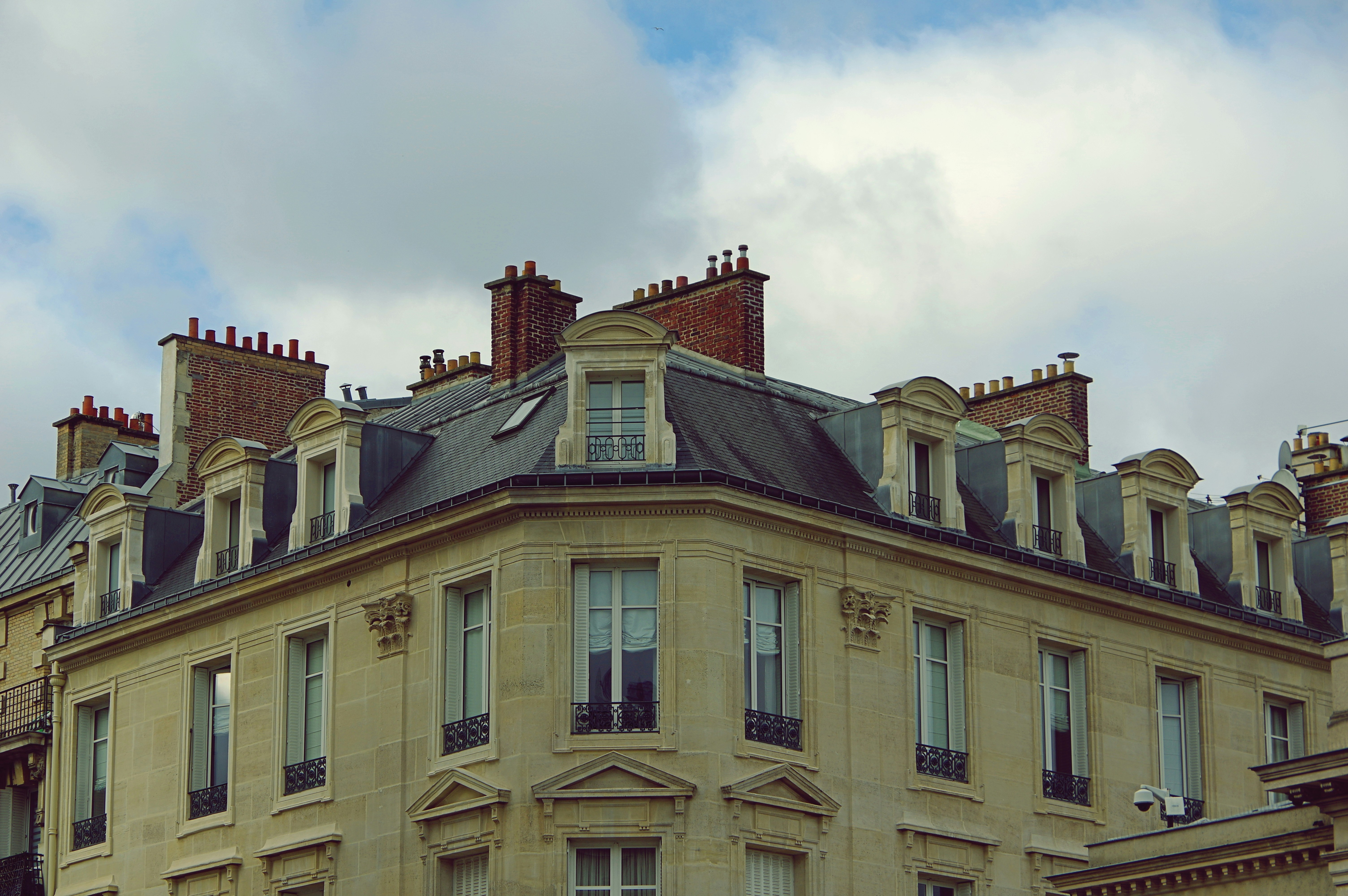 Ornate building facade with dormer windows under clouds