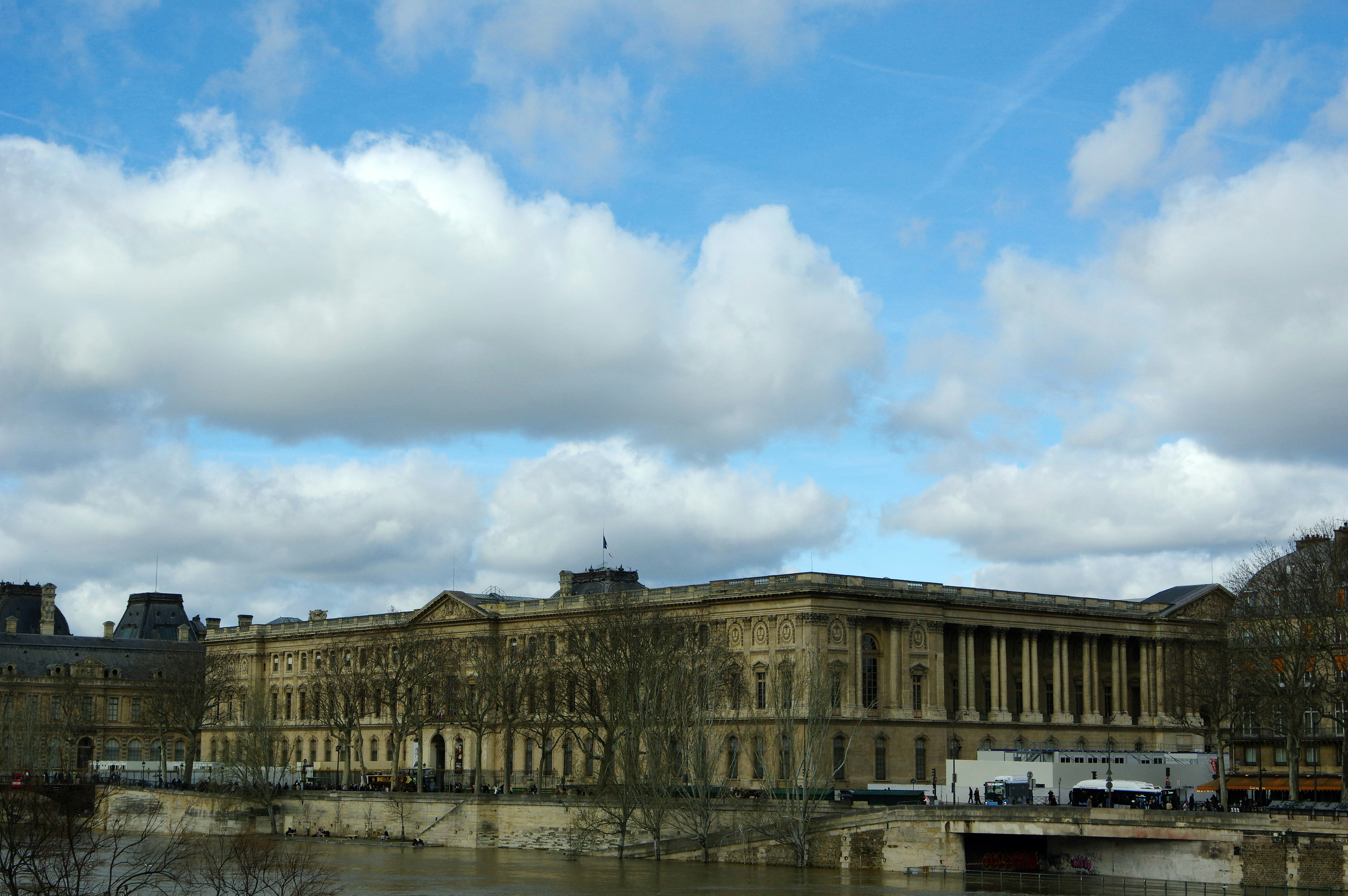 A grand building with columns beside a river.