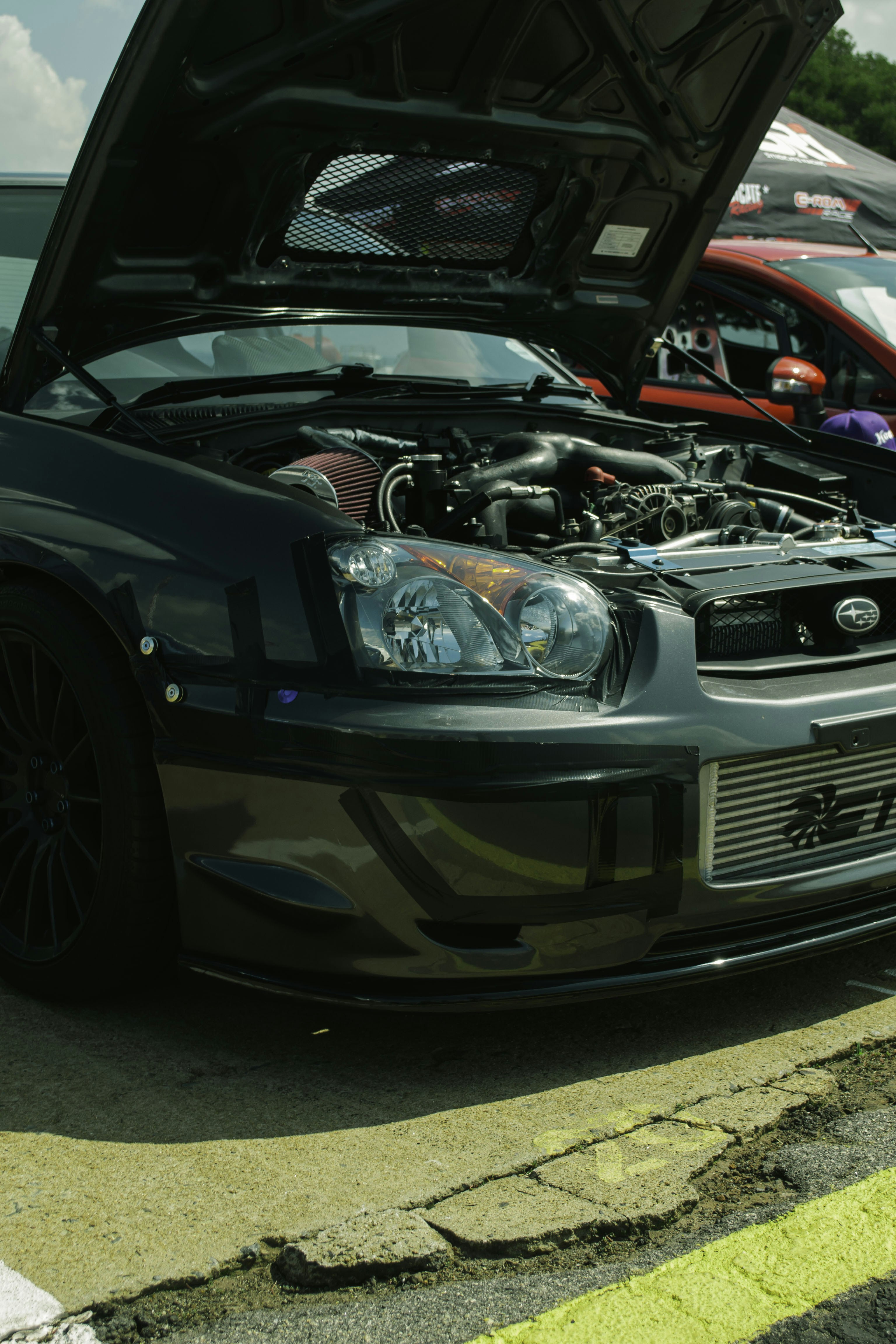 Subaru sombre avec capot ouvert montrant le moteur