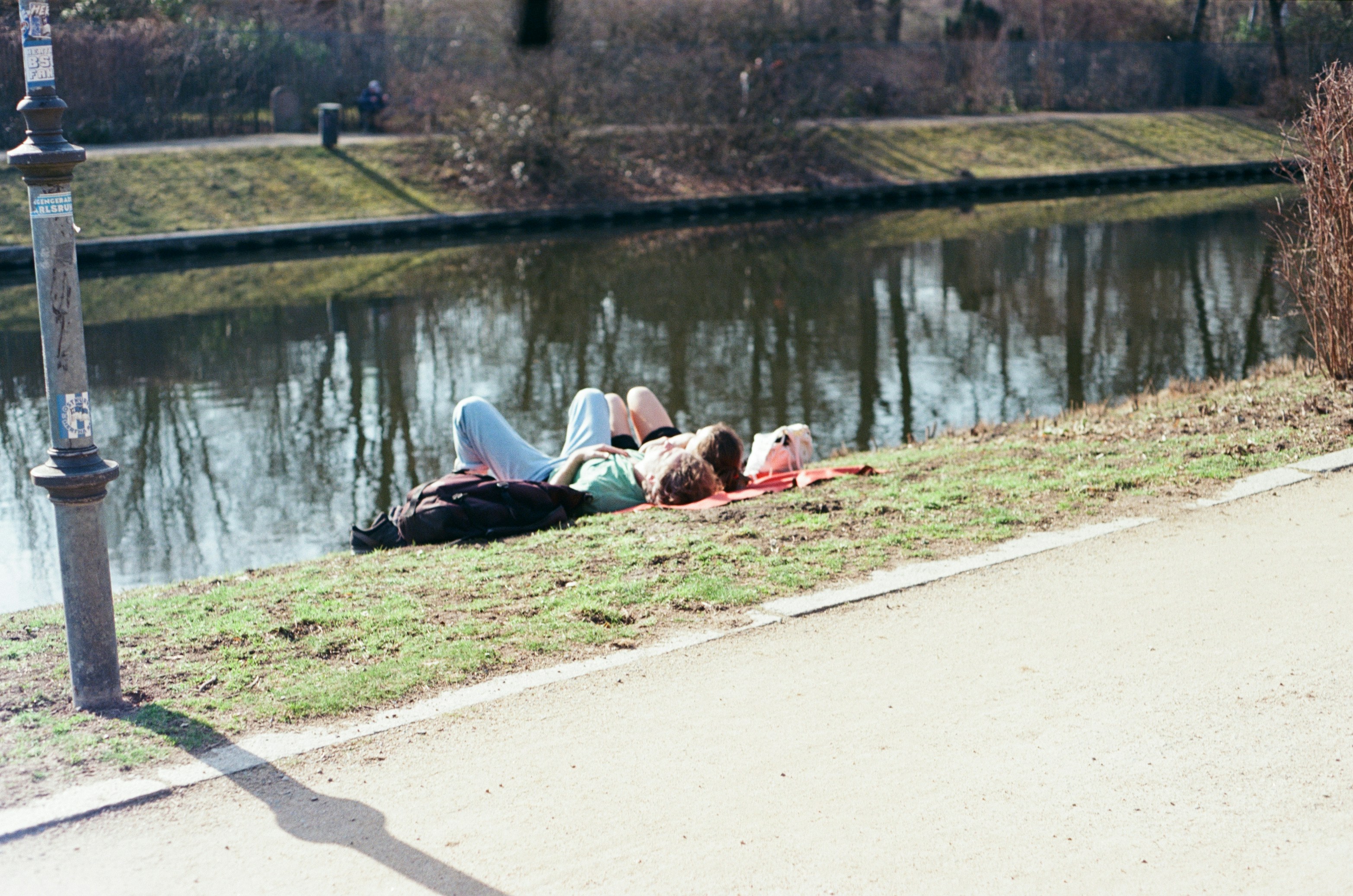 Two people relaxing by a calm canal
