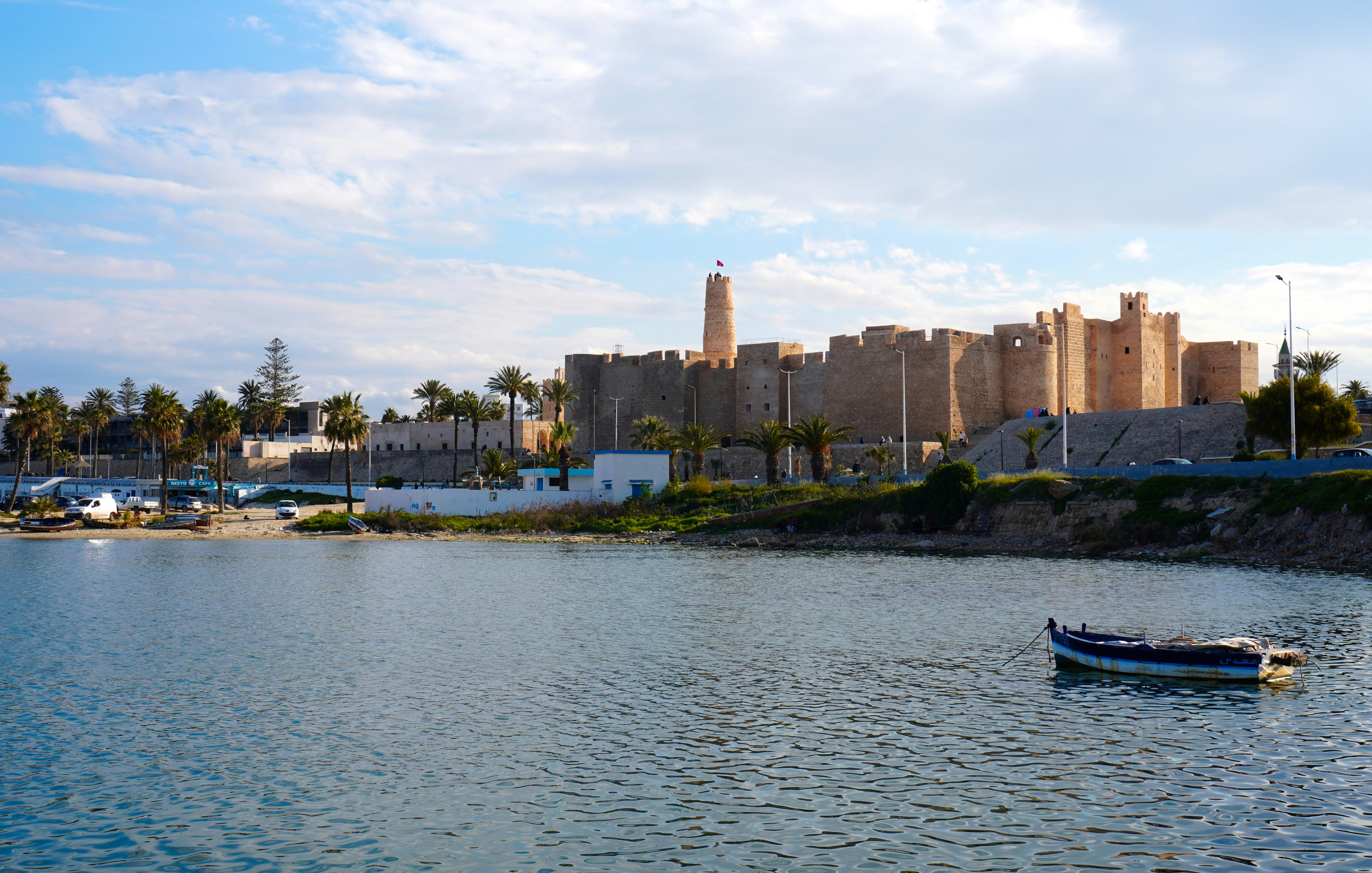 A coastal city with ancient architecture and a calm bay