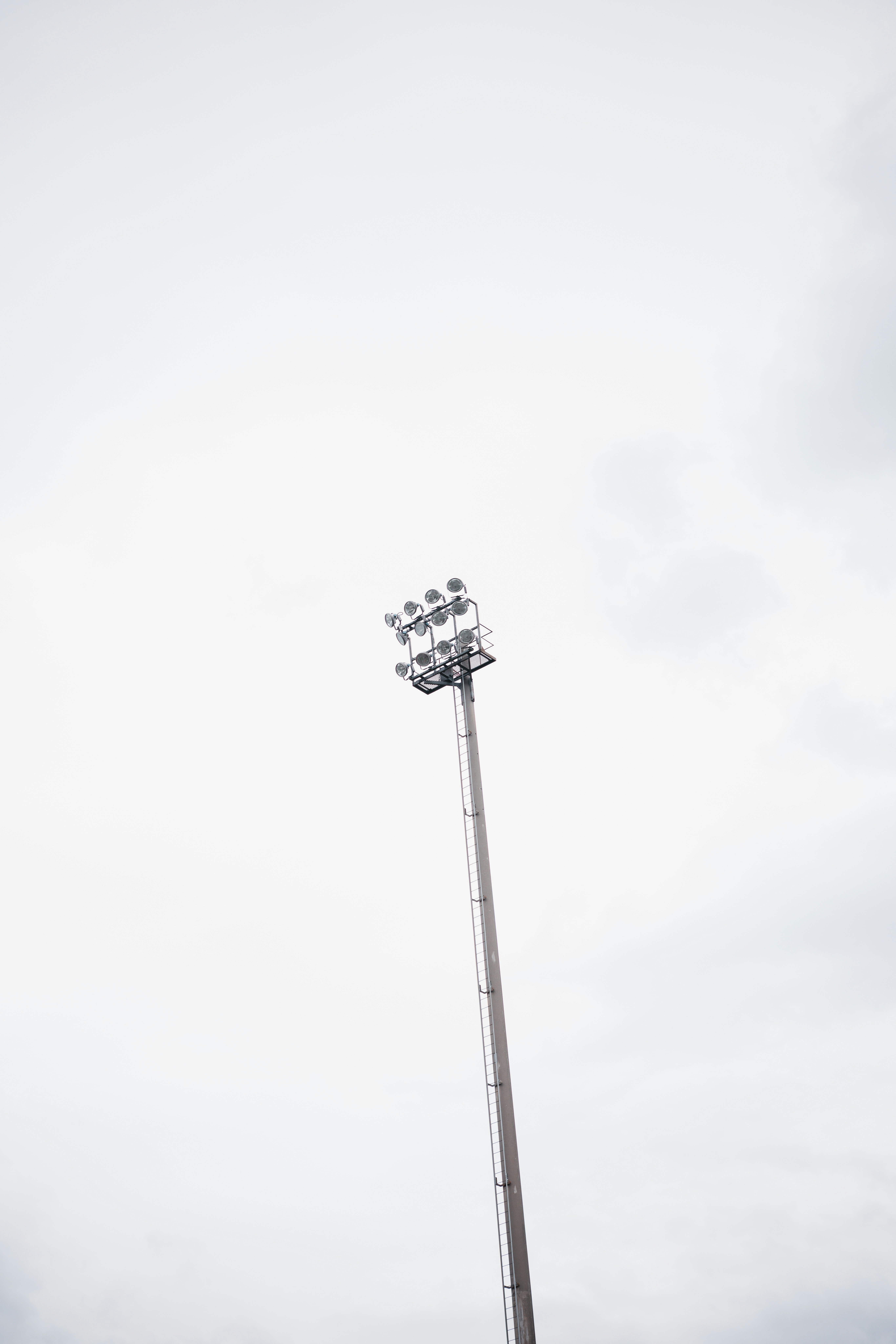 Ein hoher Stadion-Laternenmast gegen einen bewölkten Himmel.