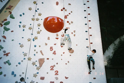 Children climbing a colorful indoor rock wall
