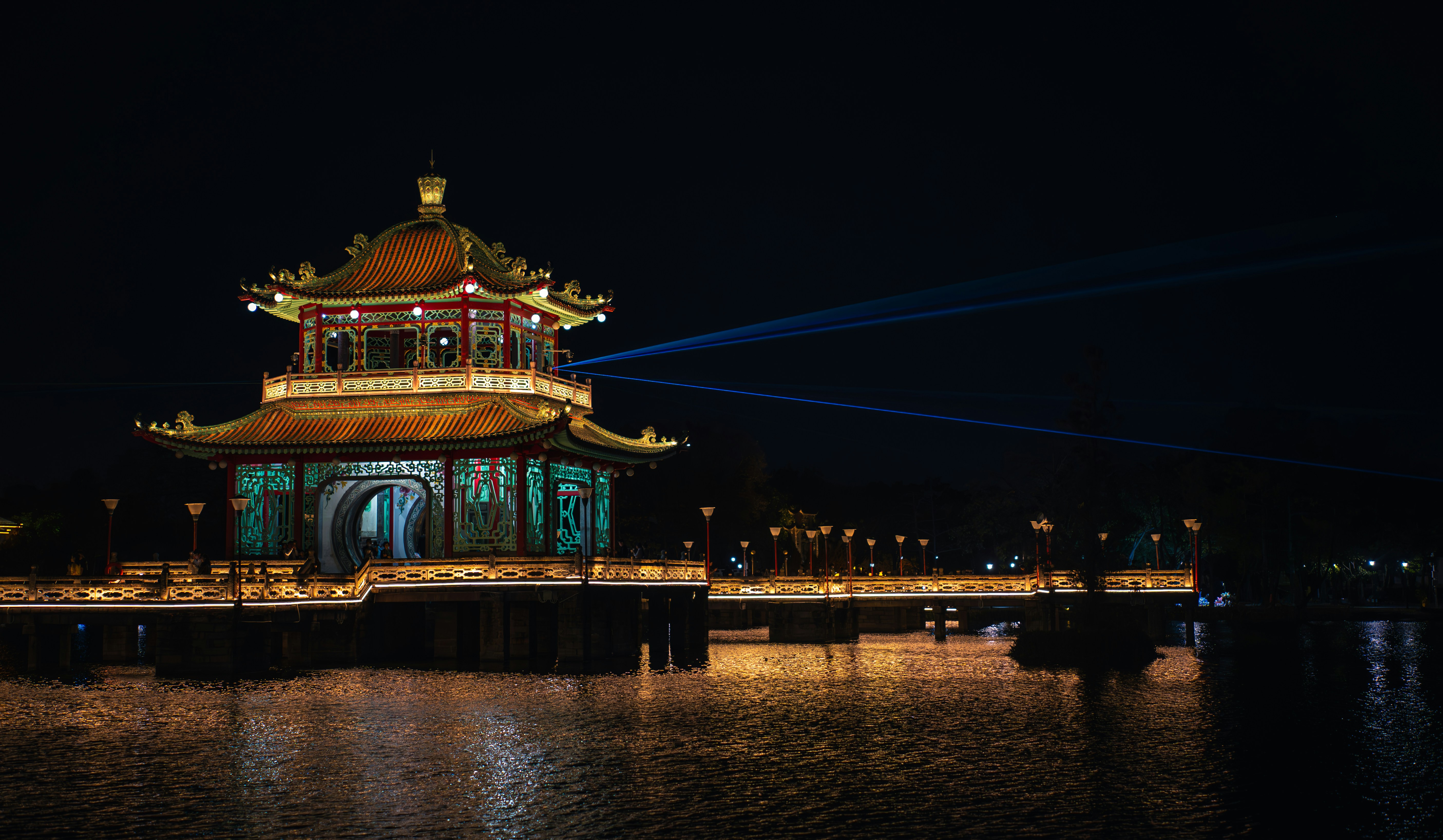 Illuminated traditional building at night over water