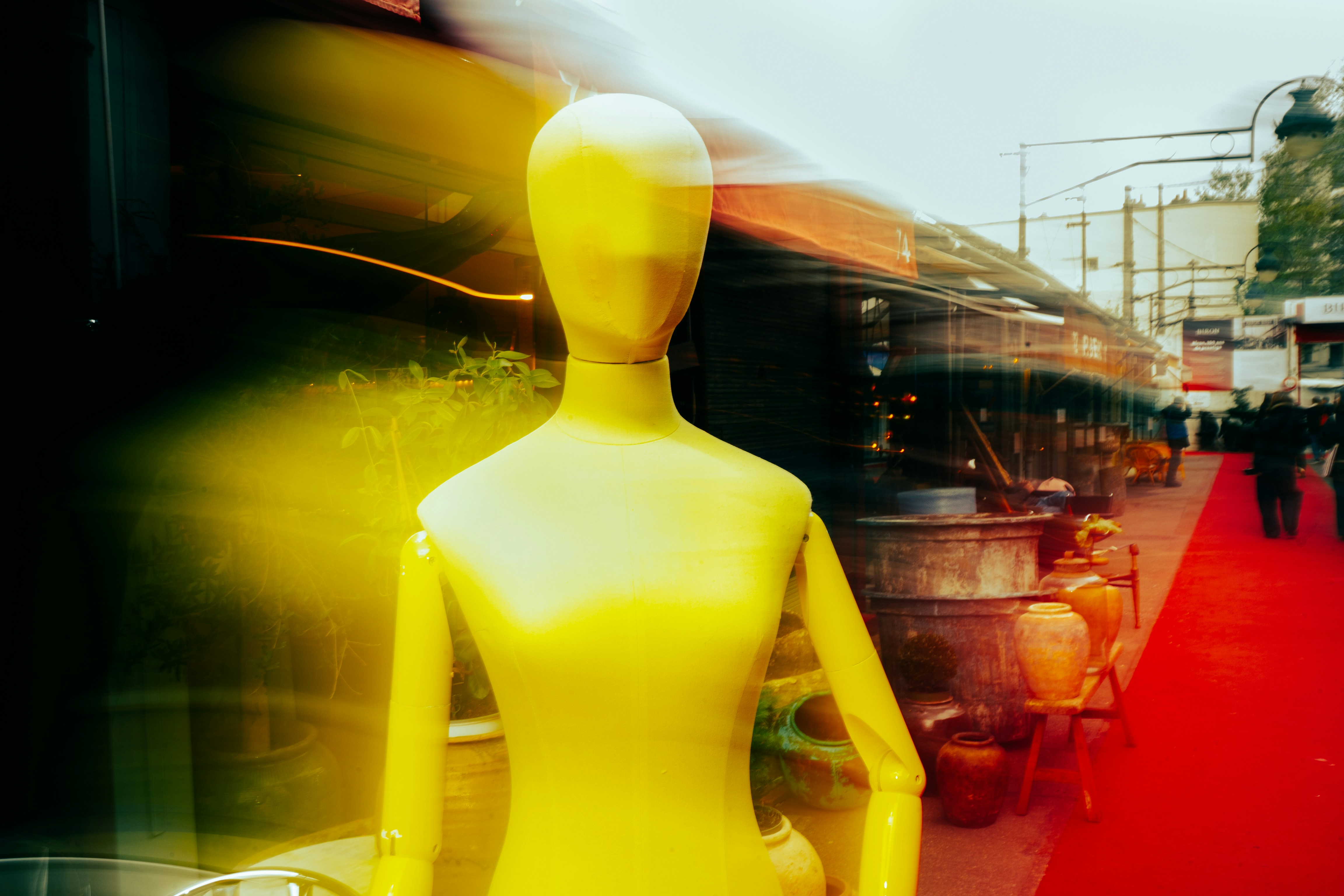 Mannequin jaune devant un étal flou