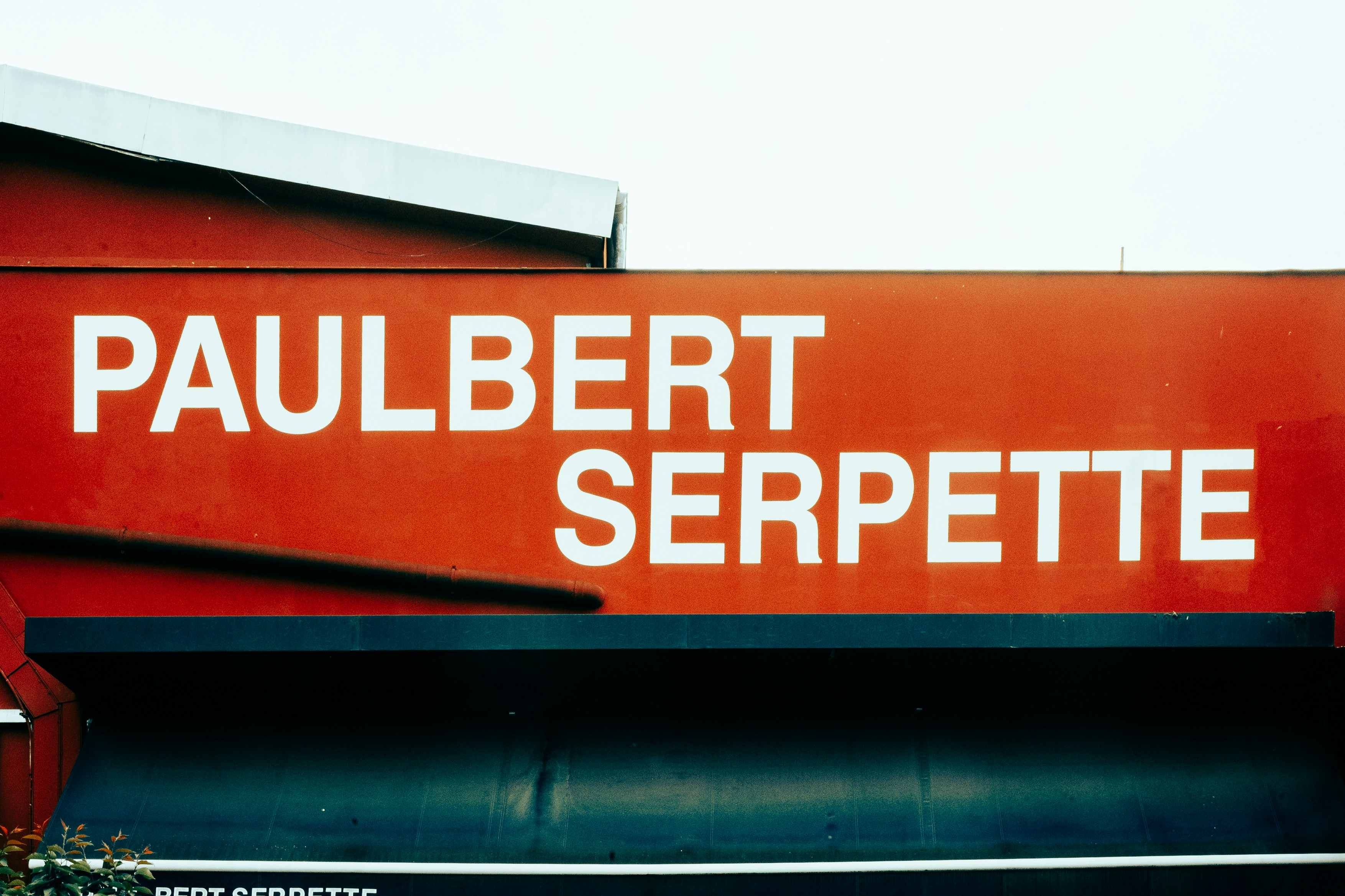 Red panel with white text paulbert serpette