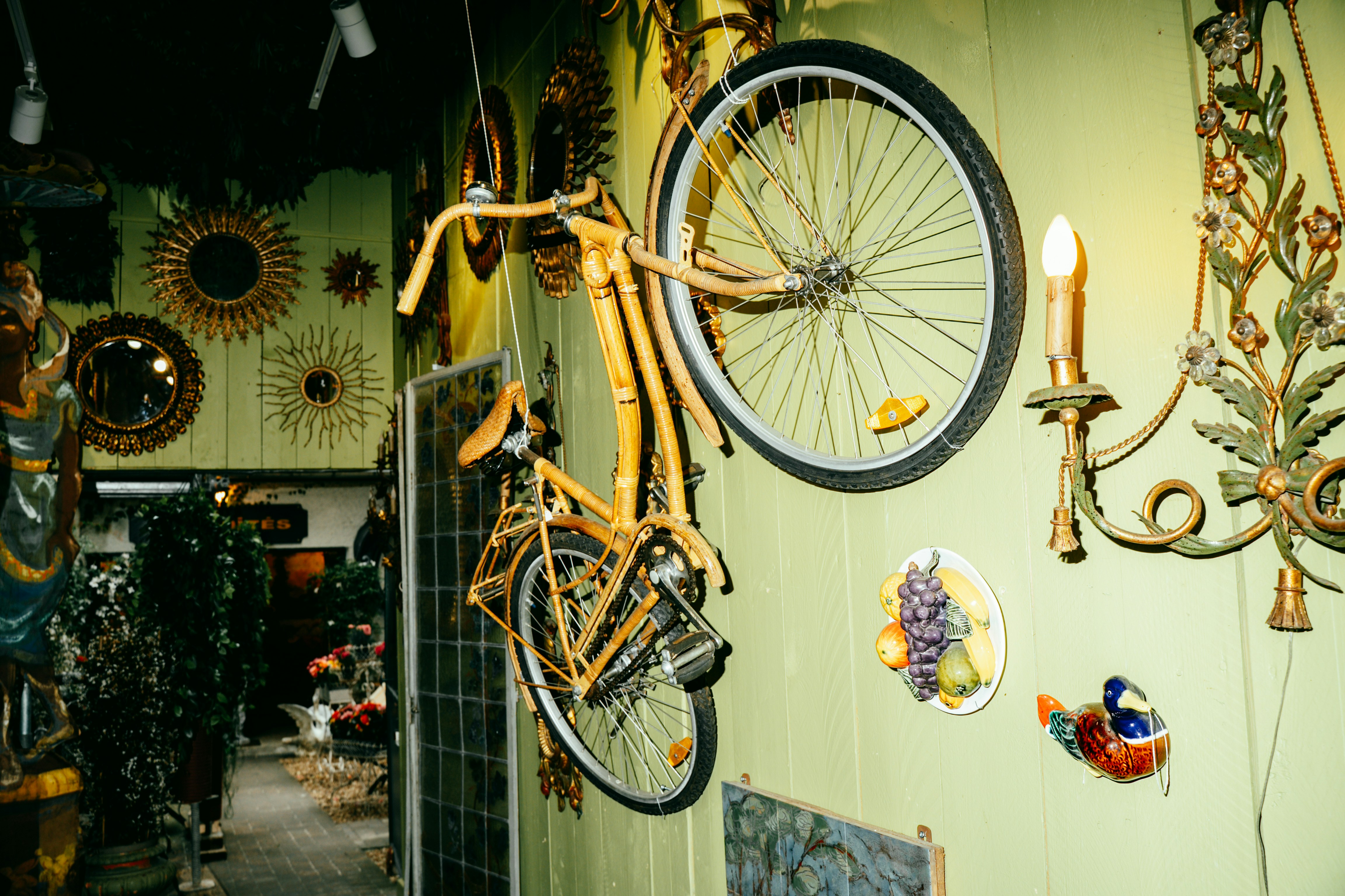 Bicicletta gialla appesa a un muro verde chiaro