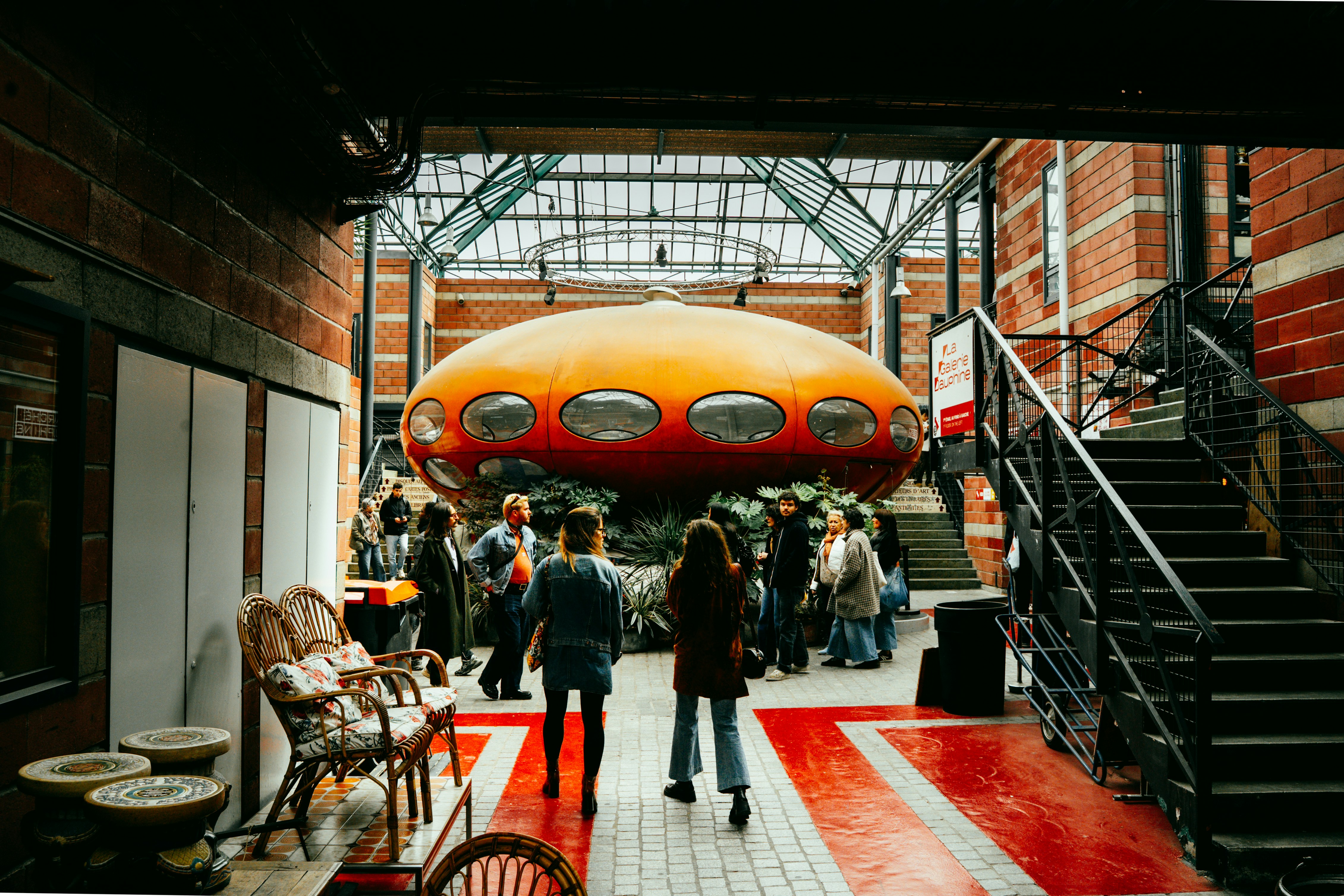 사람들이 있는 건물 안에 있는 오렌지색 미래 구조물